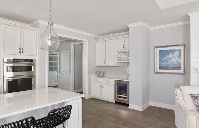 Optional Beverage Center with white cabinets, tile backsplash, wine refrigerator and wine storage ar