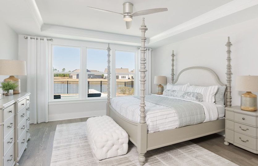 Owner's Suite with tray ceilings and large windows bringing in natural sunlight.