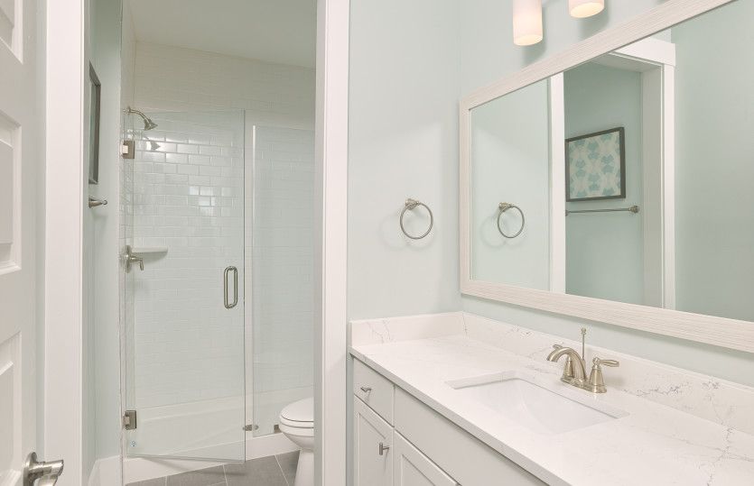 Secondary Bath with a frameless walk-in shower and a large frame mirror.