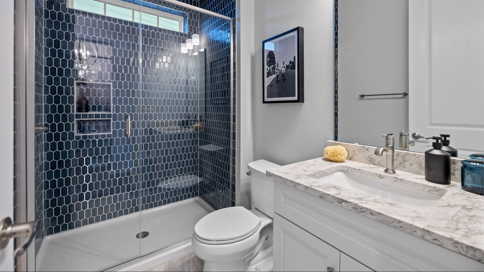 The Adventurer Plan with a modern bathroom featuring a glass-enclosed shower lined with rich navy blue tiles in Fort Mill, SC