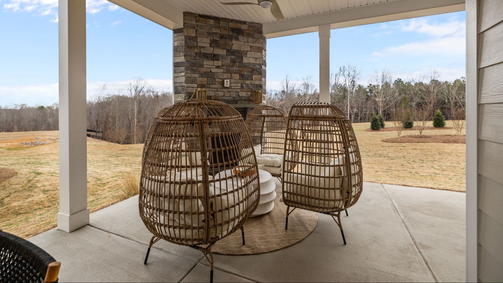 The Inspire Plan by DBR Homes a spacious rear porch with stone fireplace in Fort Mill, SC