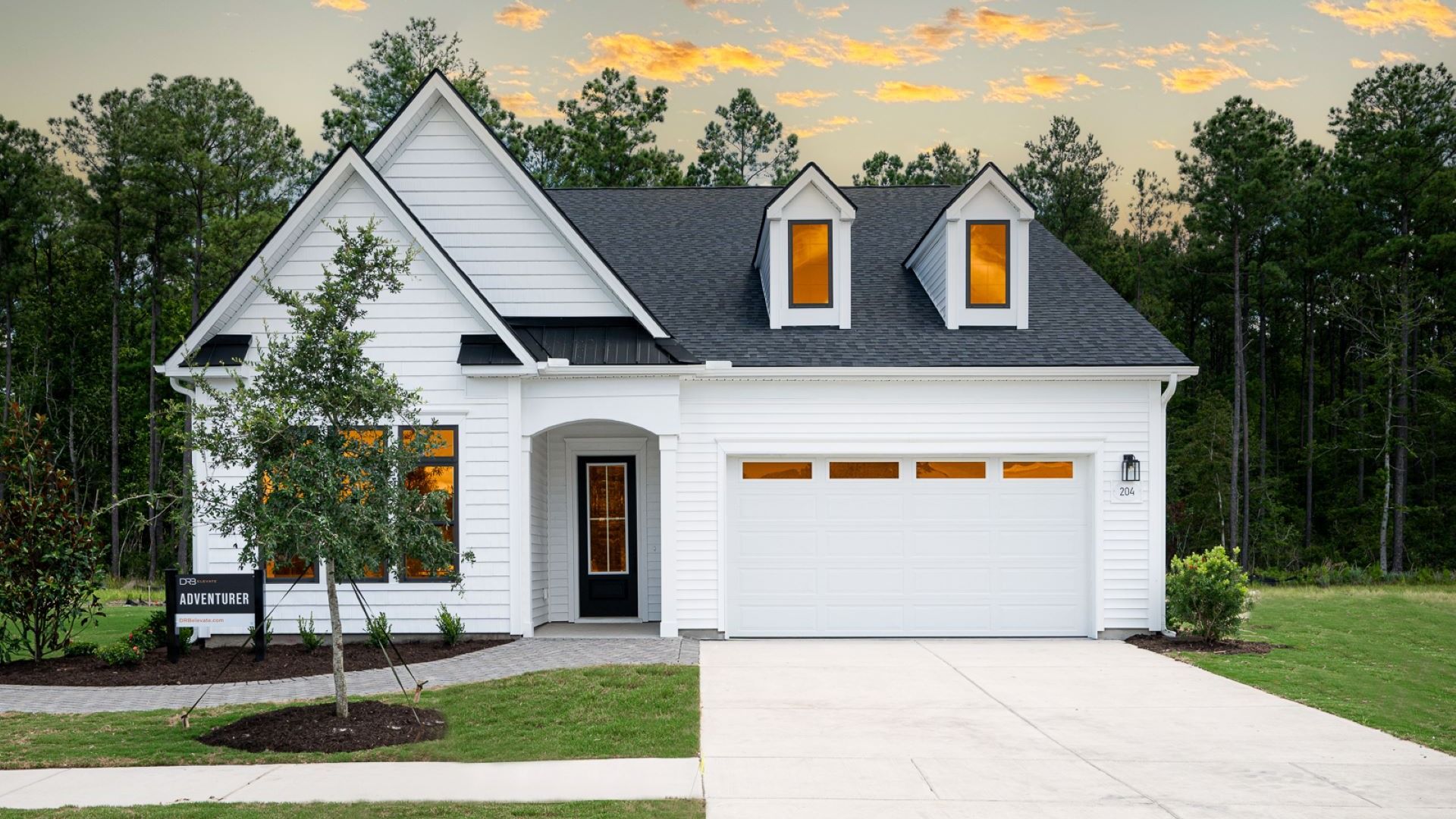Adventurer model in Lakes of Cane Bay community Summerwind Crossing features an amazing white wood exterior with black trim