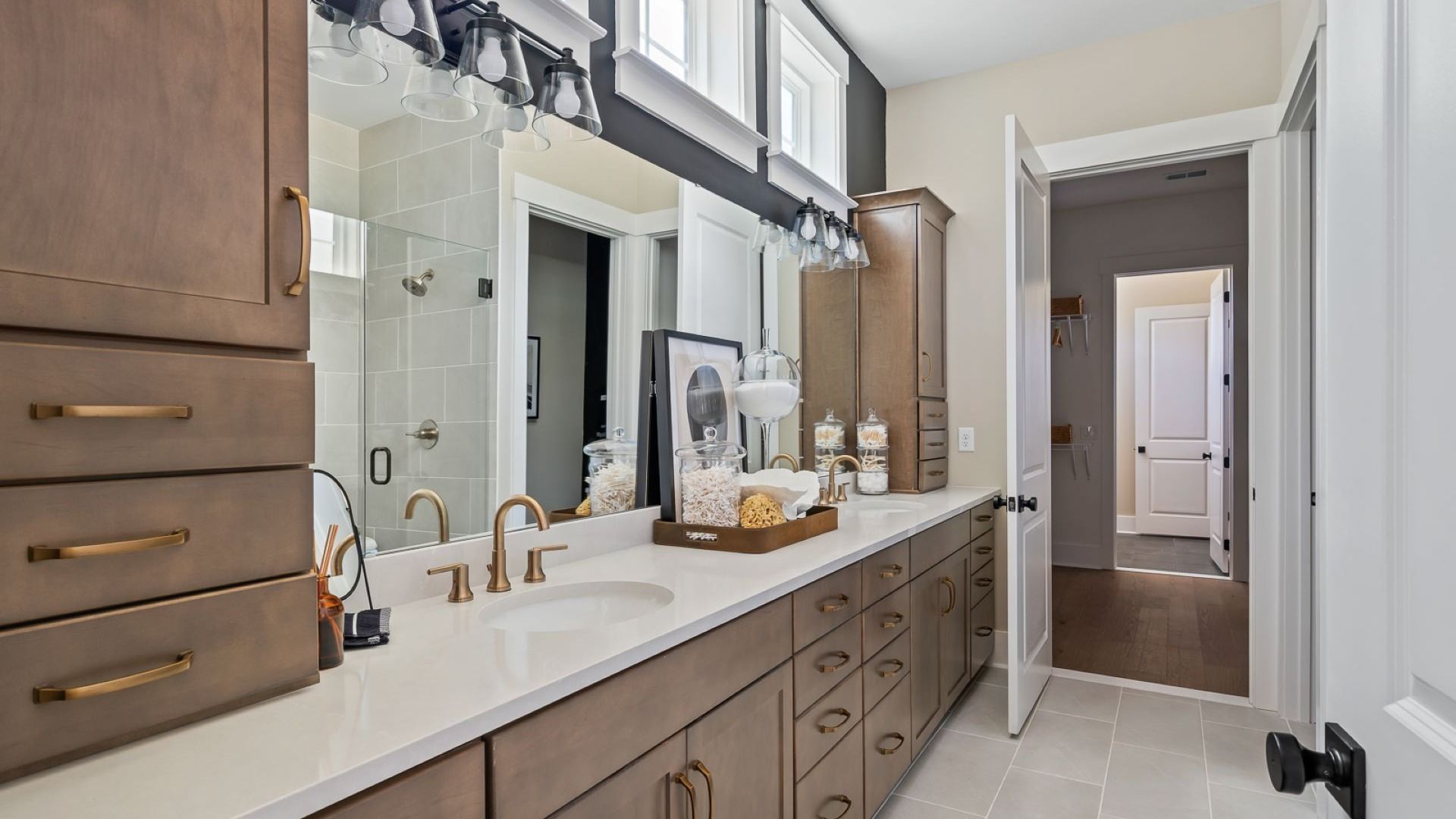 Summerwind Crossing at Lakes of Cane Bay owner's suite bath features dark wood cabinets and great light fixtures