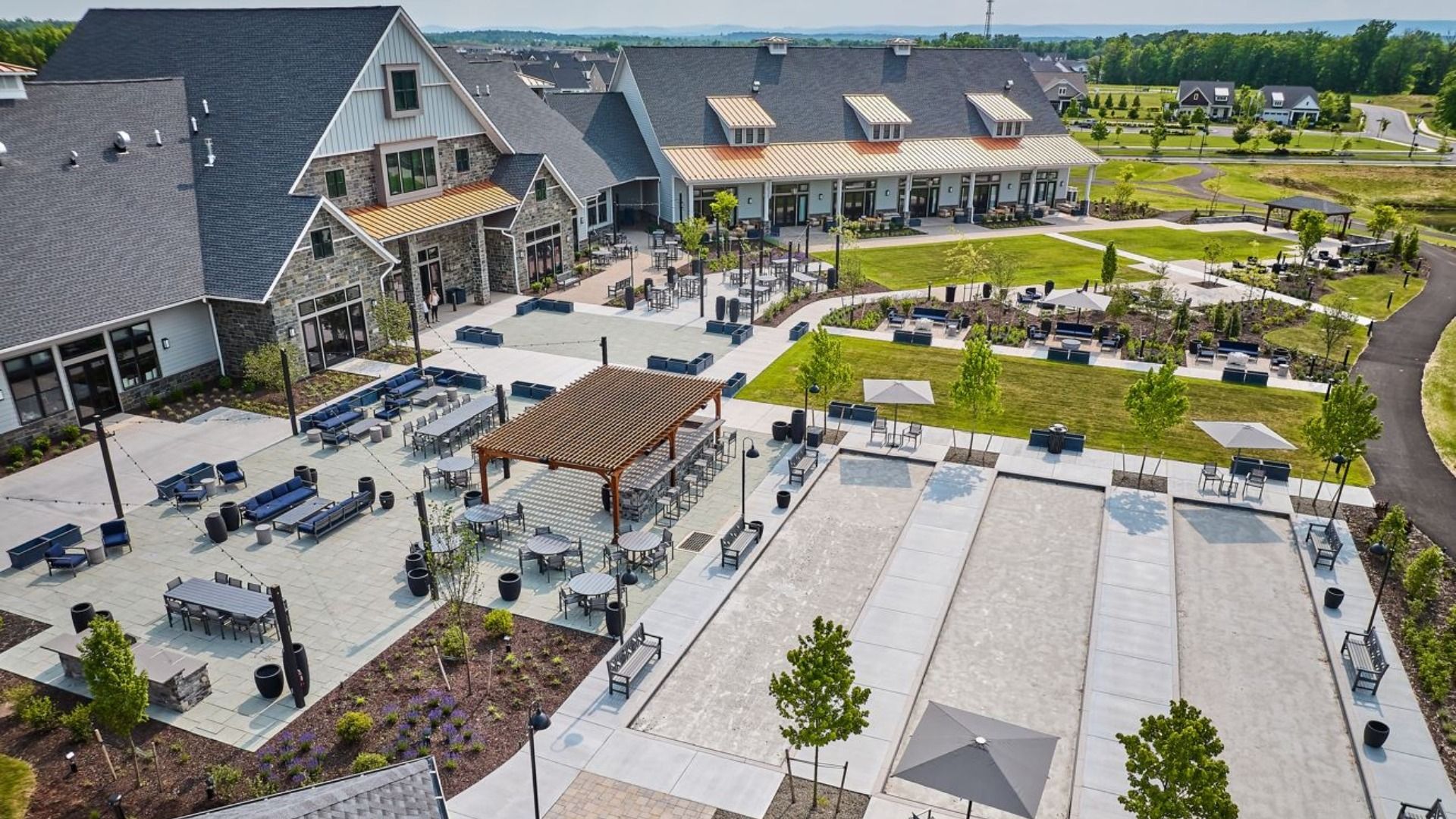 Bird’s-eye view of the Amblebrook Clubhouse and Great Lawn with lush greenery and gathering spaces.