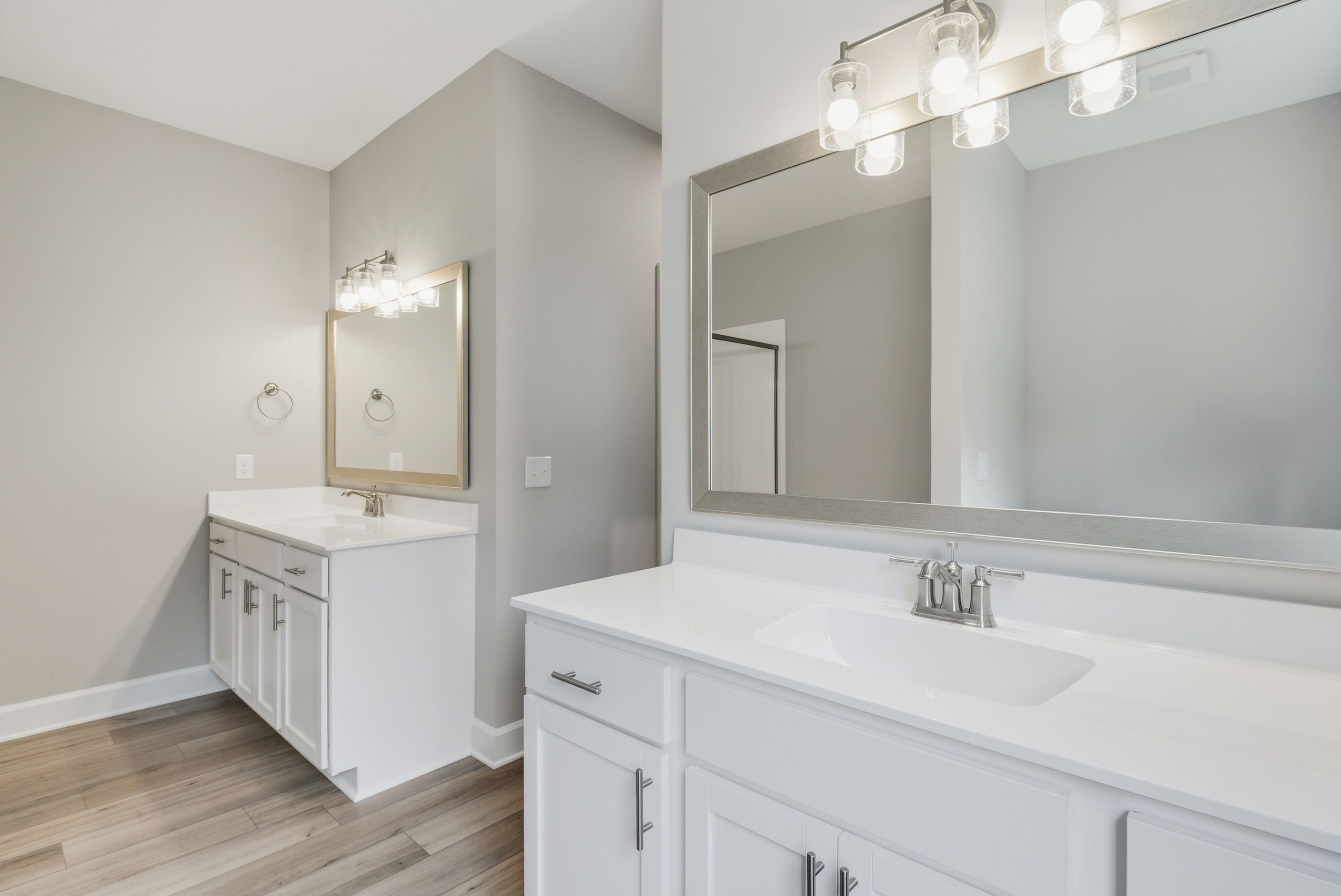Harbor II Main Primary Bathroom with Framed Mirrors and White Cabinets