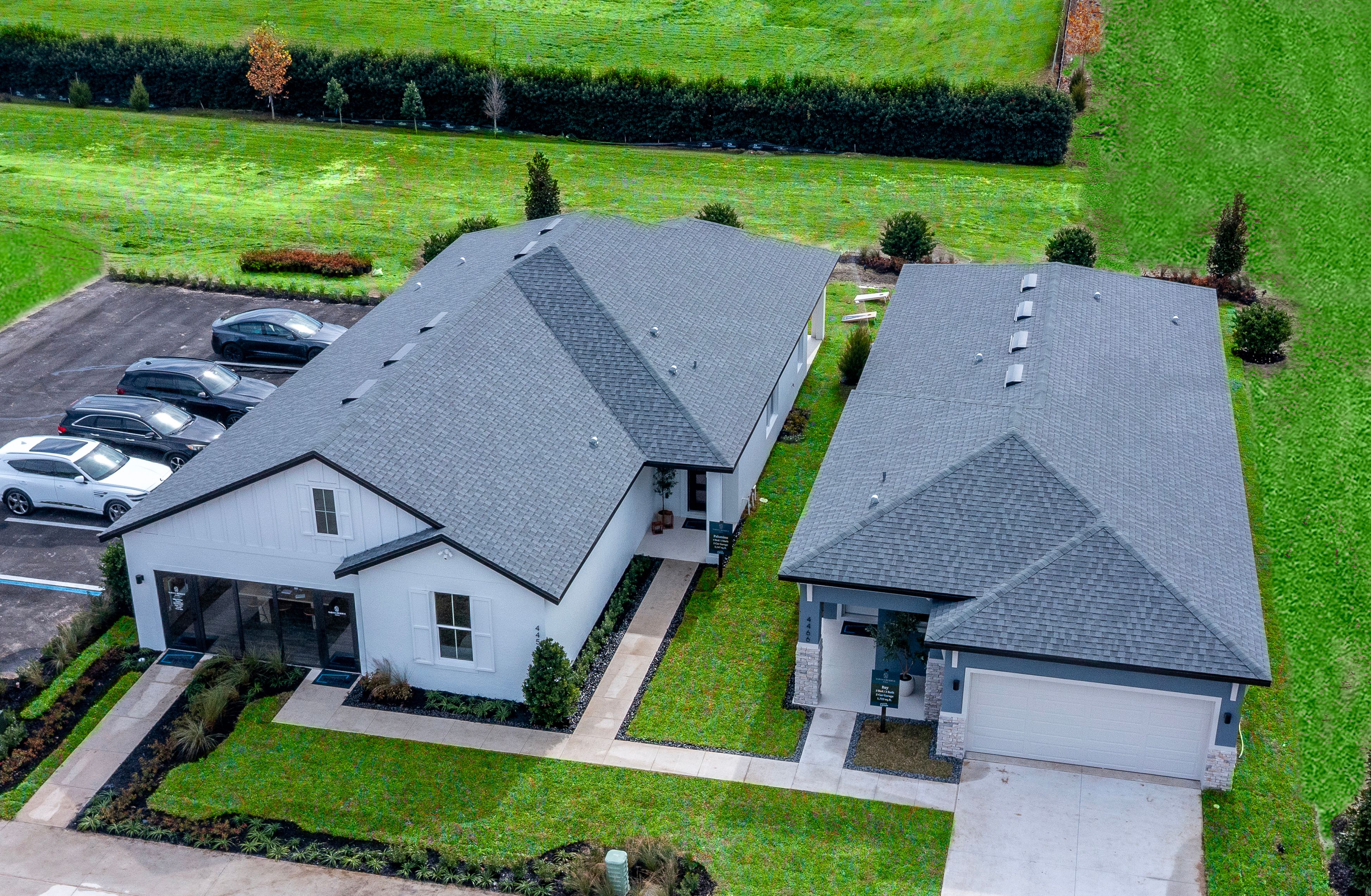 An elevated view of the Bay and Palomino model homes showcasing modern architecture, beautifully landscaped grounds, and the inviting streetscape of Sabana Reserve.