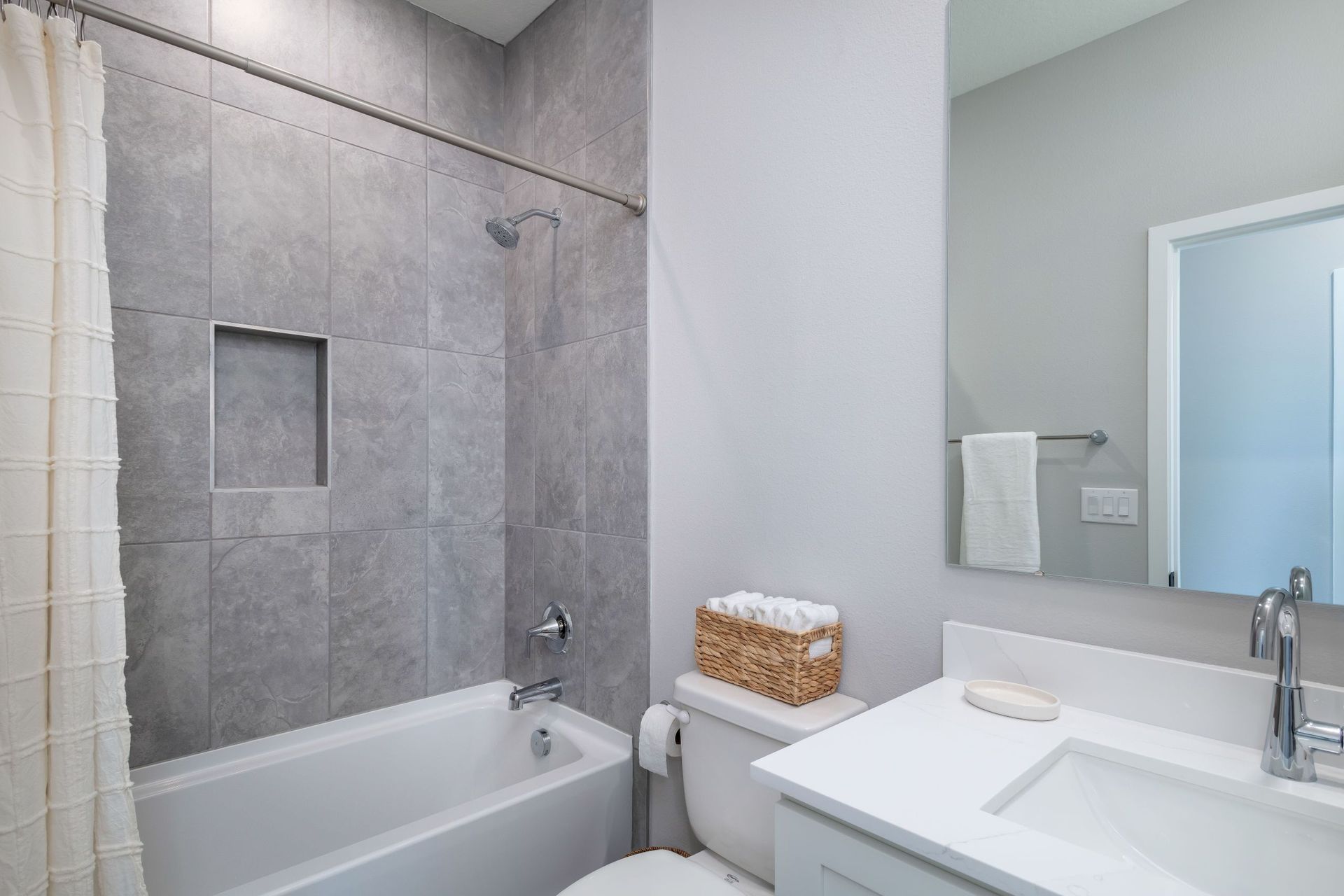 A bright and stylish secondary bathroom offering modern tilework, clean lines, and a functional layout for guests or family members.