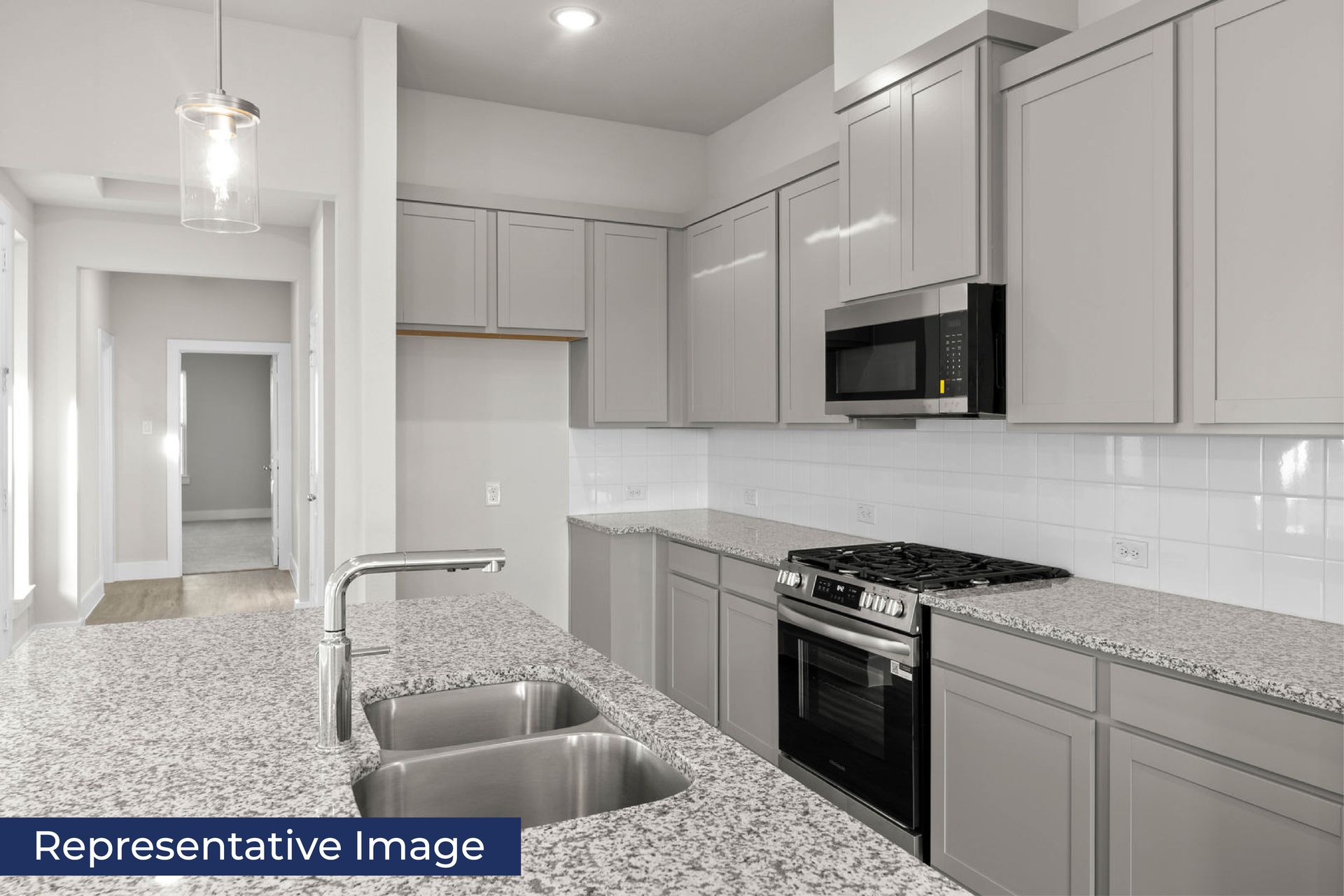 Modern kitchen with granite countertops, stainless steel appliances, and gray cabinets.