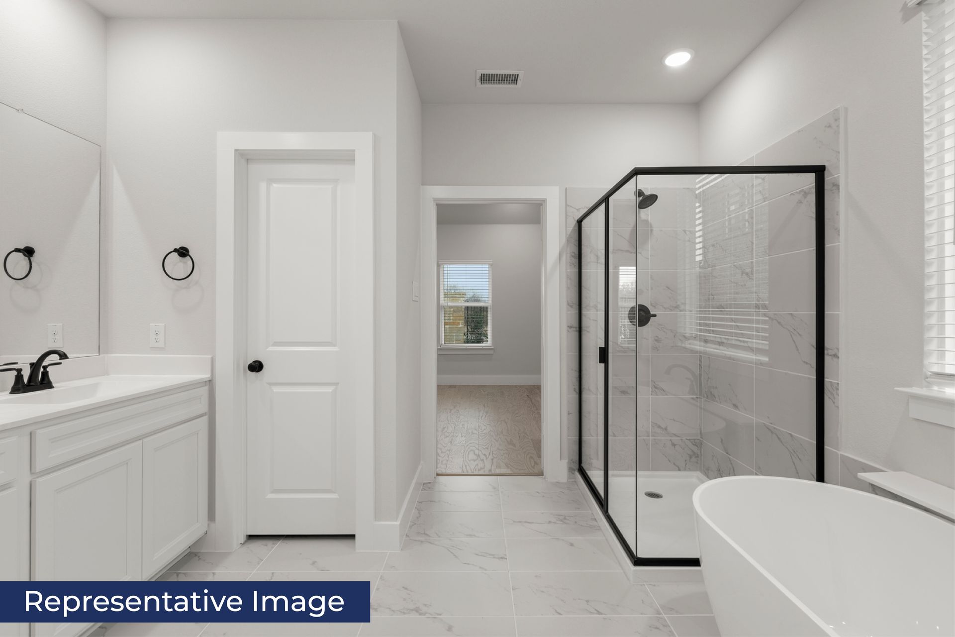 Modern bathroom with glass shower, bathtub, and white cabinetry.