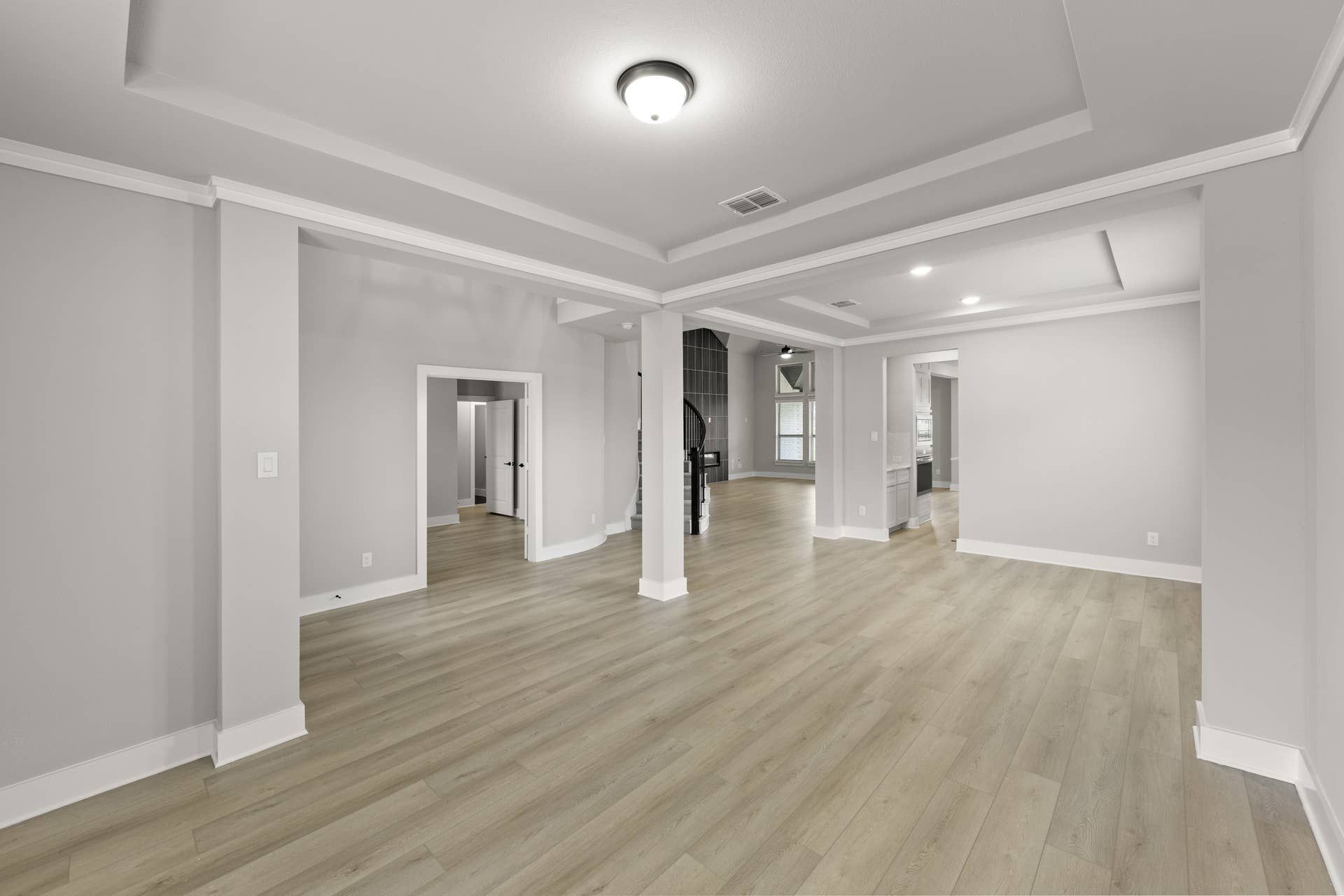 Spacious living room with coffered ceiling and hardwood floors.