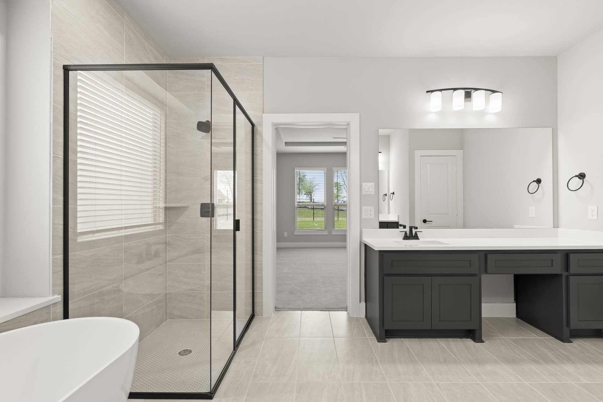 Modern bathroom with glass shower, double vanity, and freestanding bathtub.