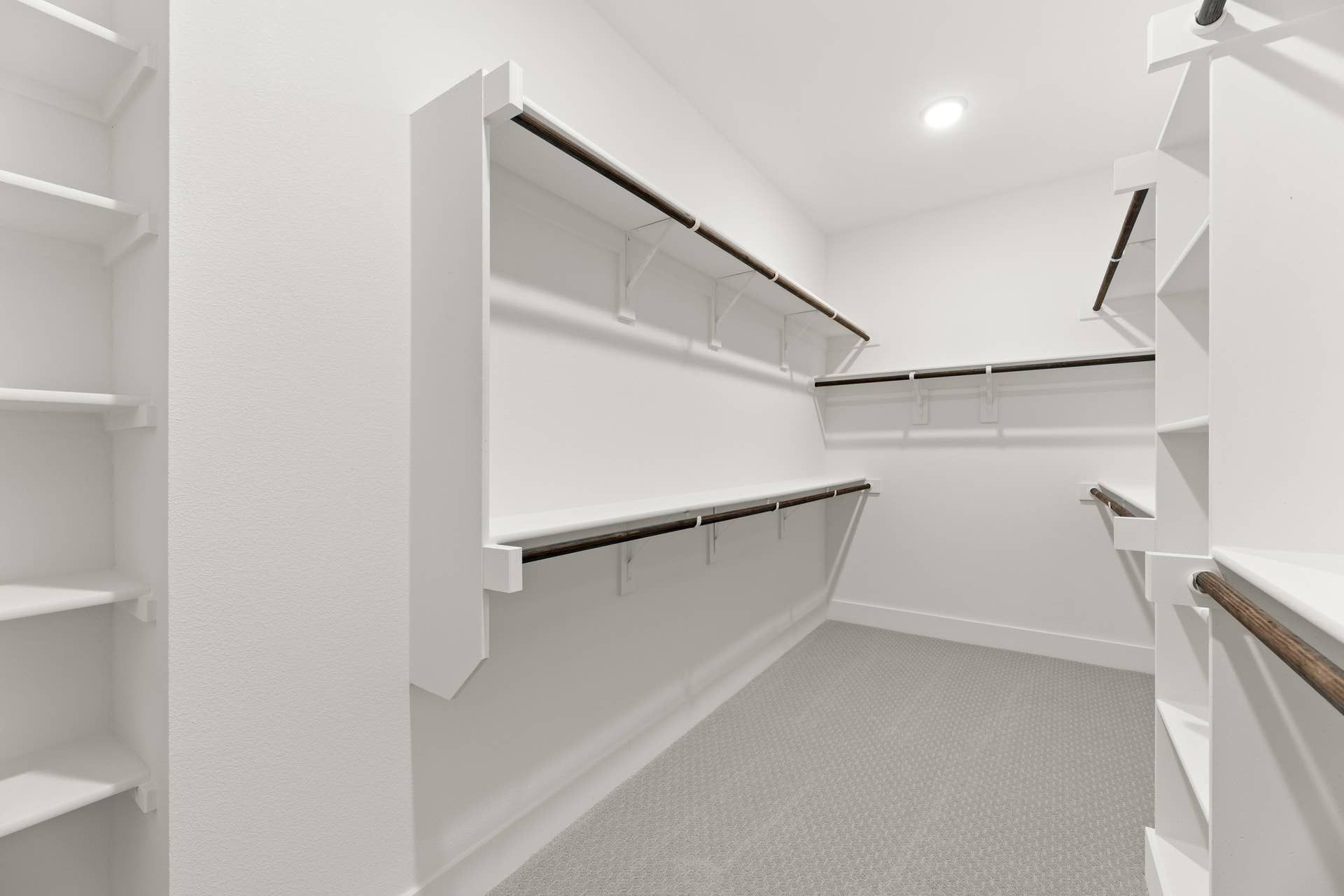 Spacious walk-in closet with multiple shelves and hanging rods.