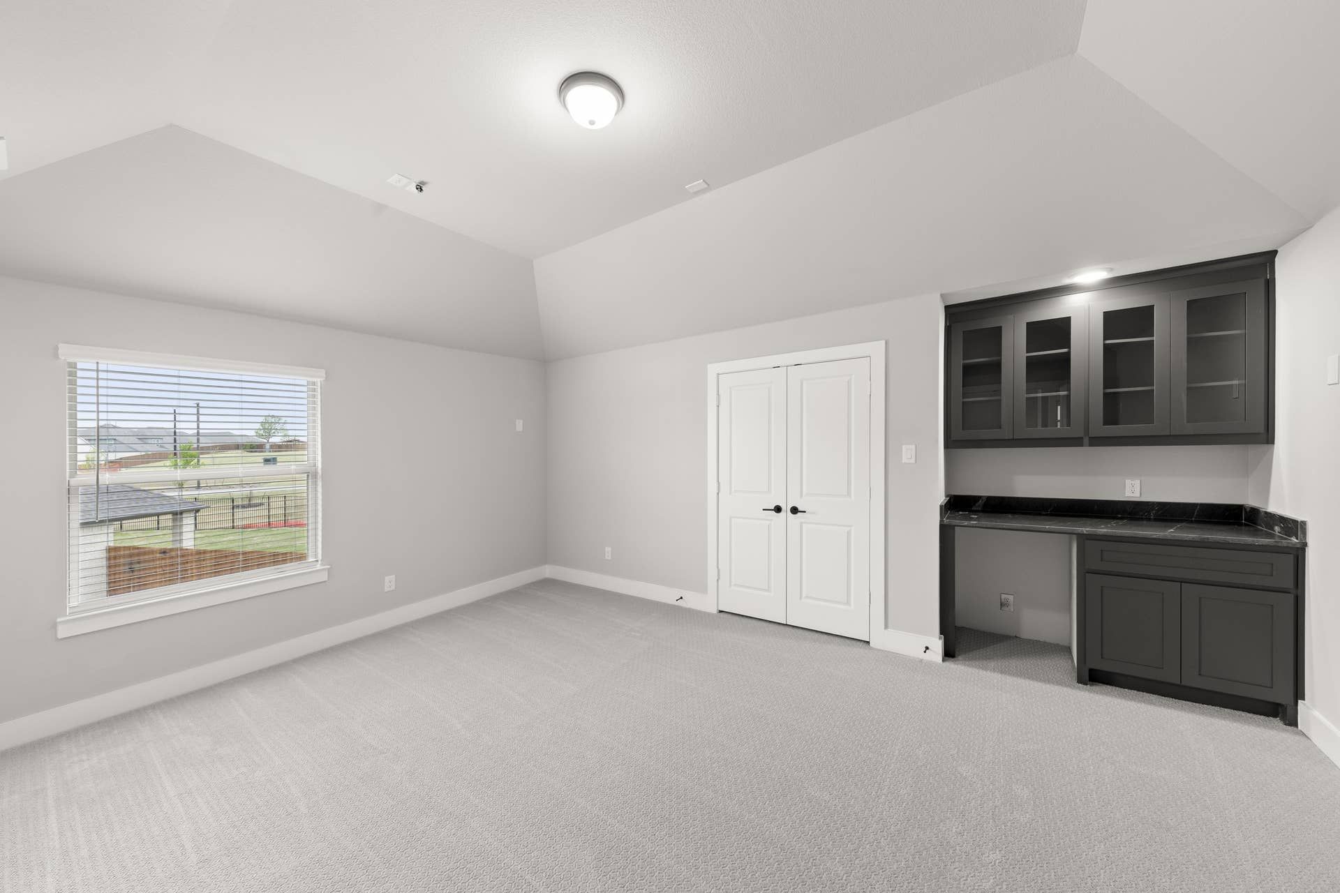 Spacious room with built-in cabinetry and large window view.
