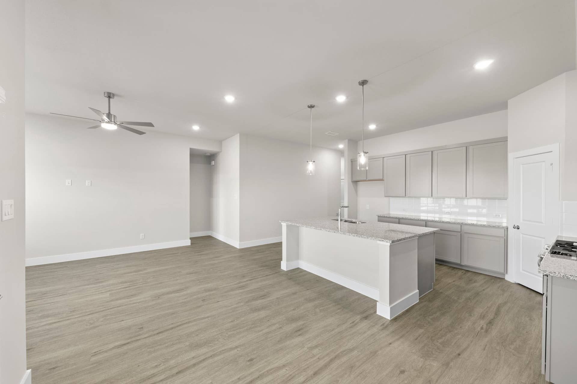 Modern kitchen and dining area with sleek cabinetry and wood flooring.