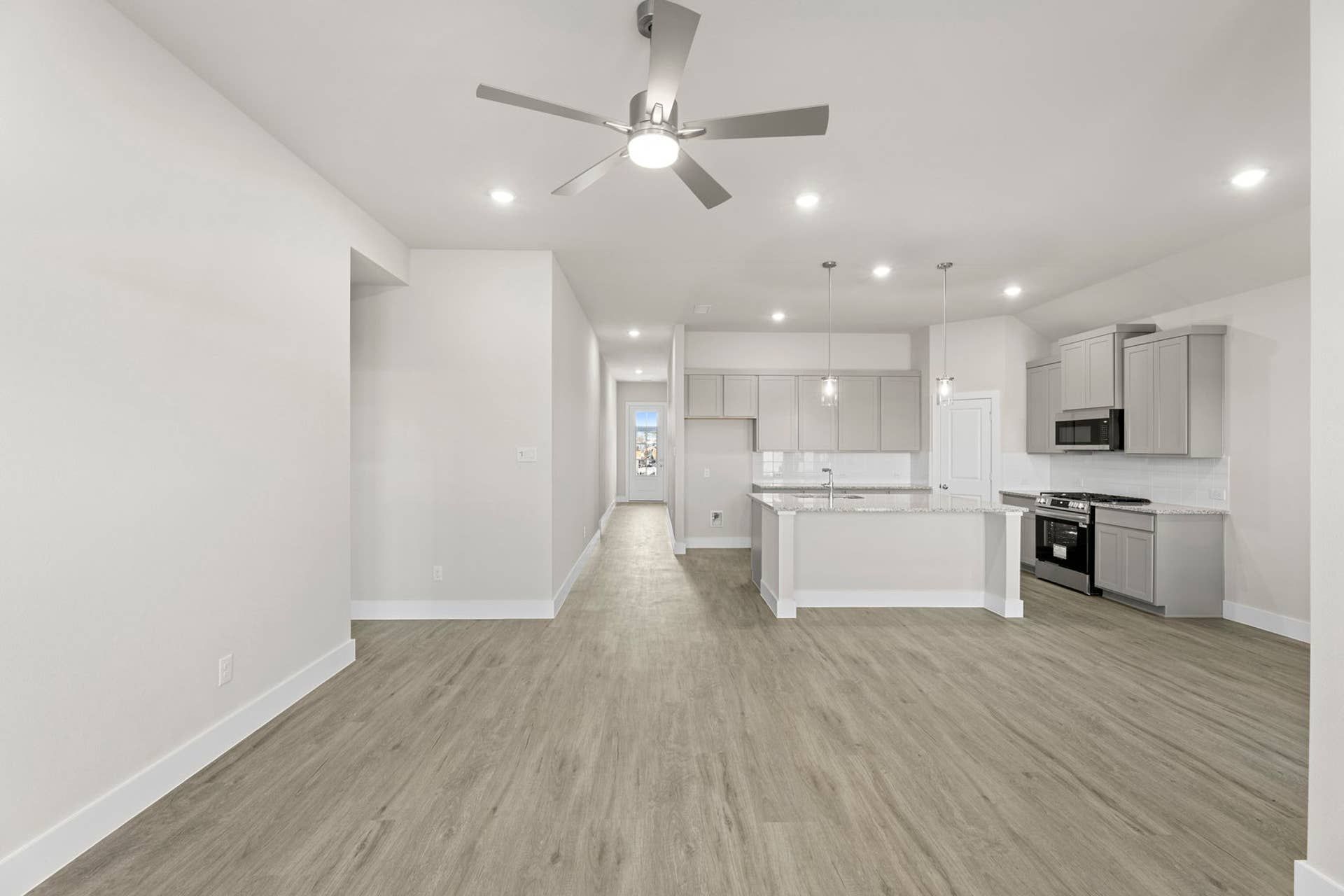 Spacious open-plan kitchen and living area with modern fixtures and wood flooring.