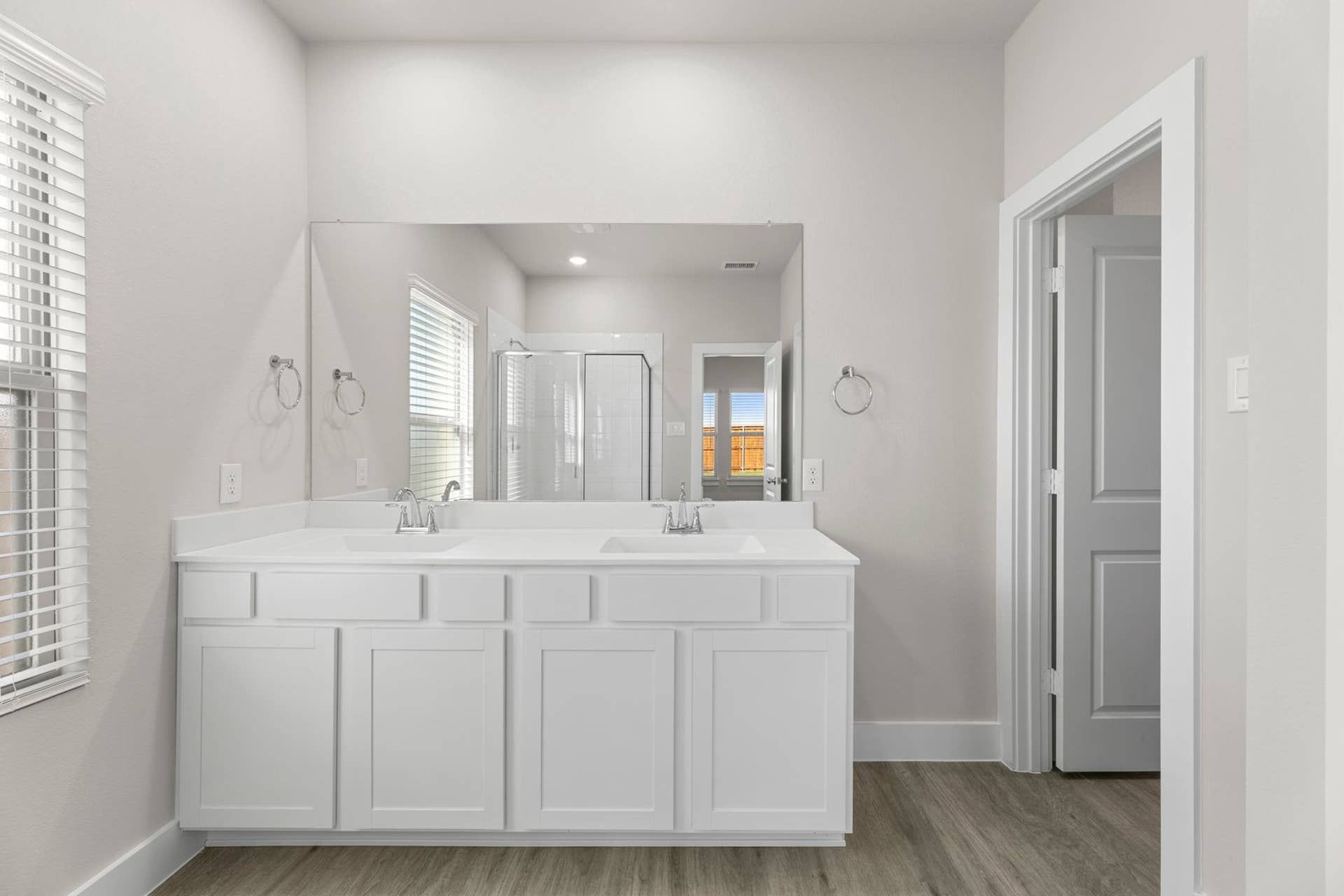 Modern bathroom with dual sinks and glass-enclosed shower.
