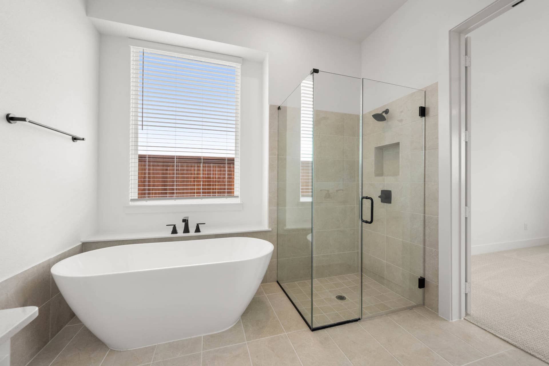 Primary suite bathroom with freestanding tub and glass-enclosed walk-in shower