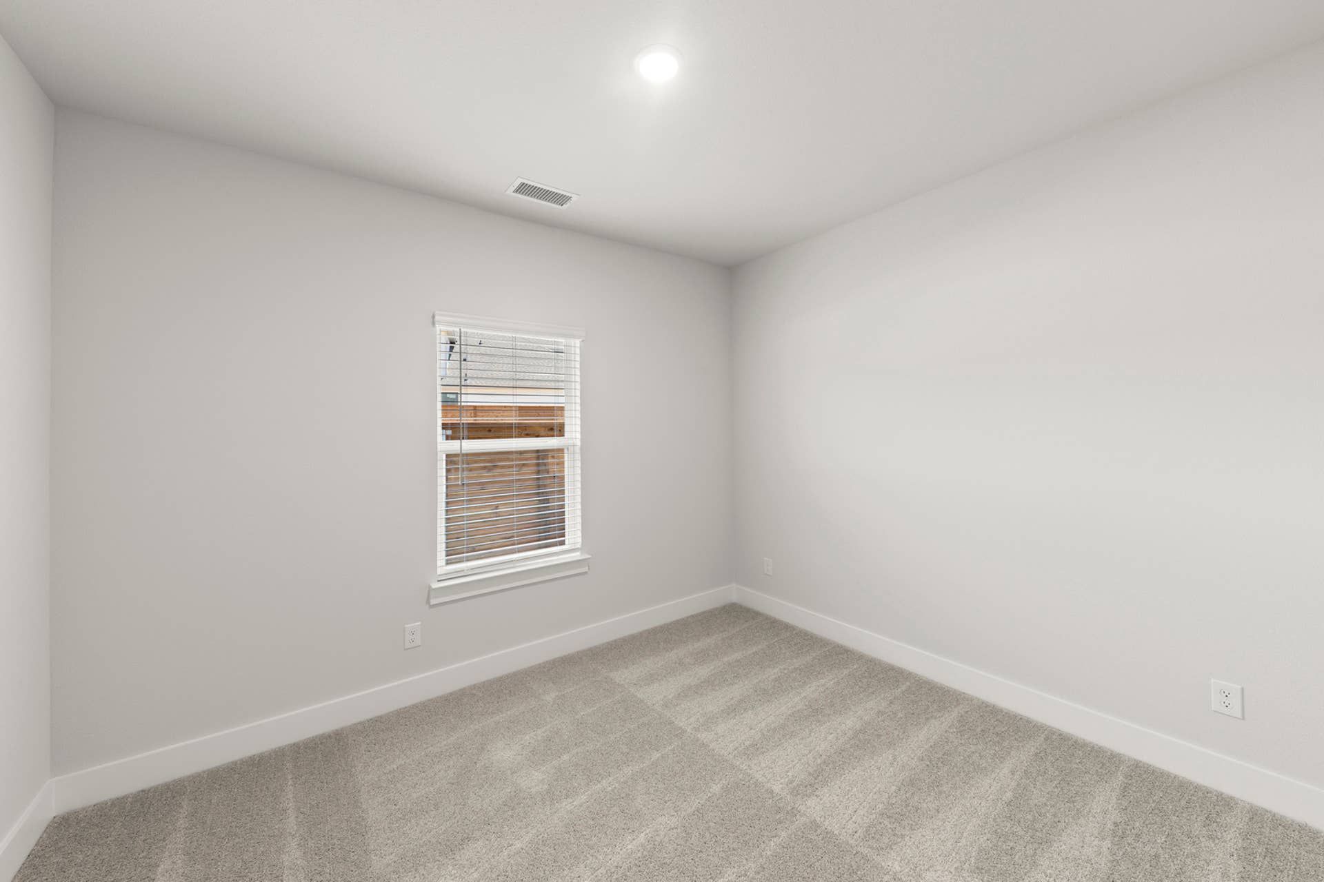 Carpeted secondary bedroom with neutral walls, recessed lighting, and single window with blinds