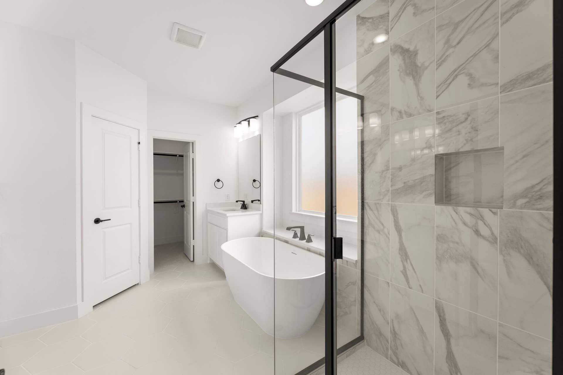 Elegant bathroom with freestanding tub, marble shower, and modern fixtures.