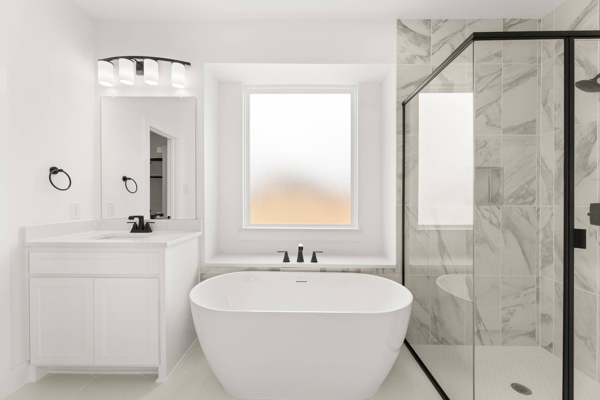 Modern bathroom with freestanding tub, glass shower, and sleek vanity.