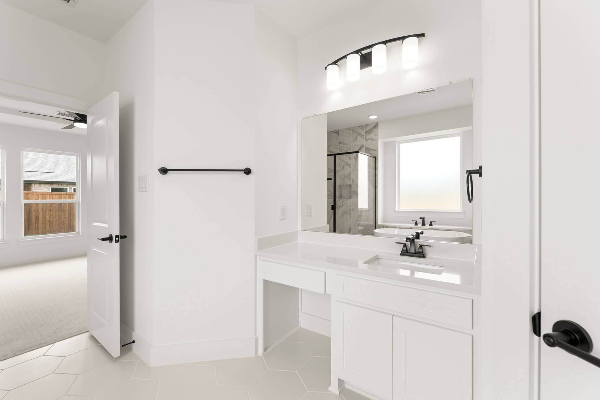 Bright modern bathroom with dual sinks, large mirror, and glass-enclosed shower.
