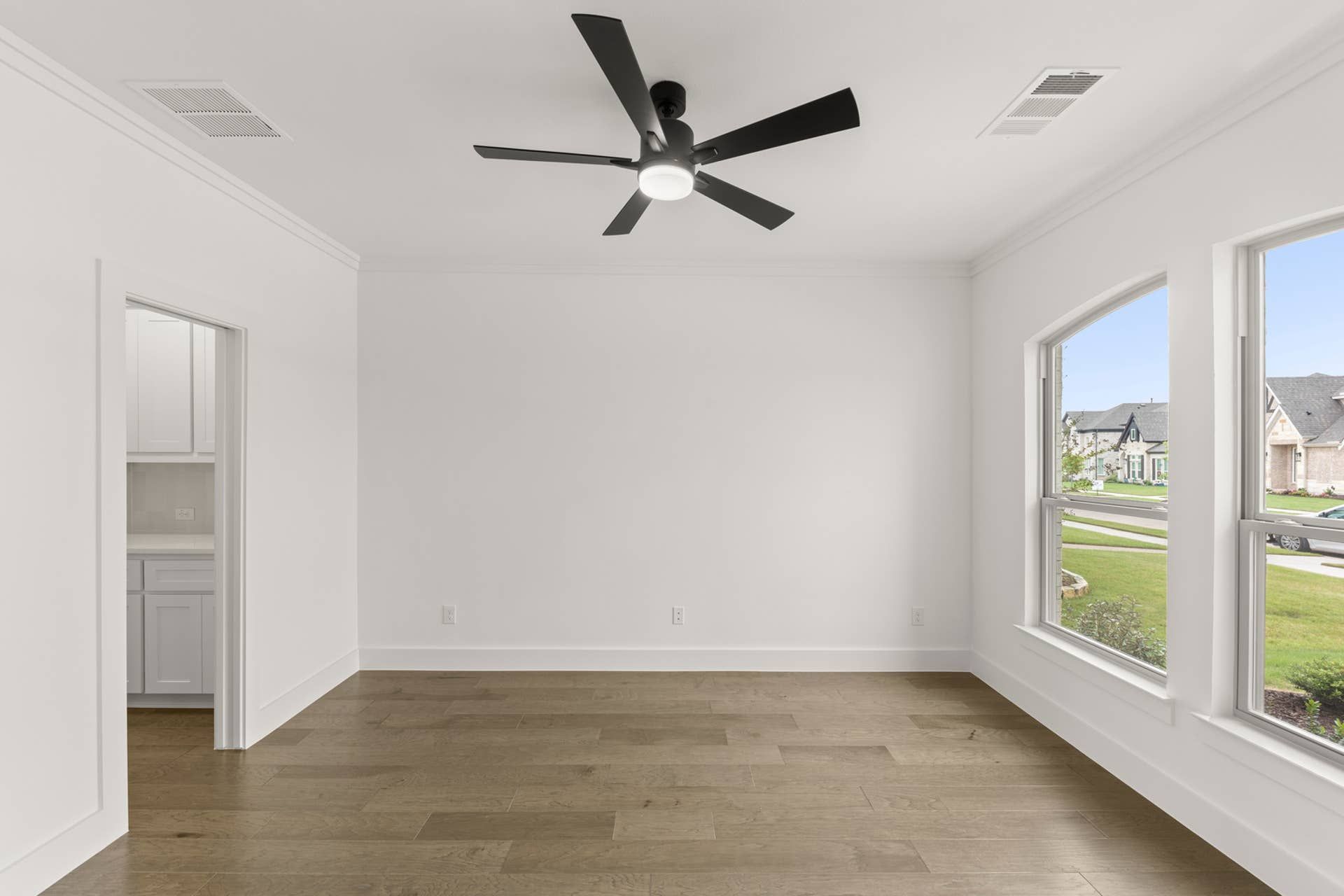 Representative photo of modern dining room with ceiling fan and large windows.