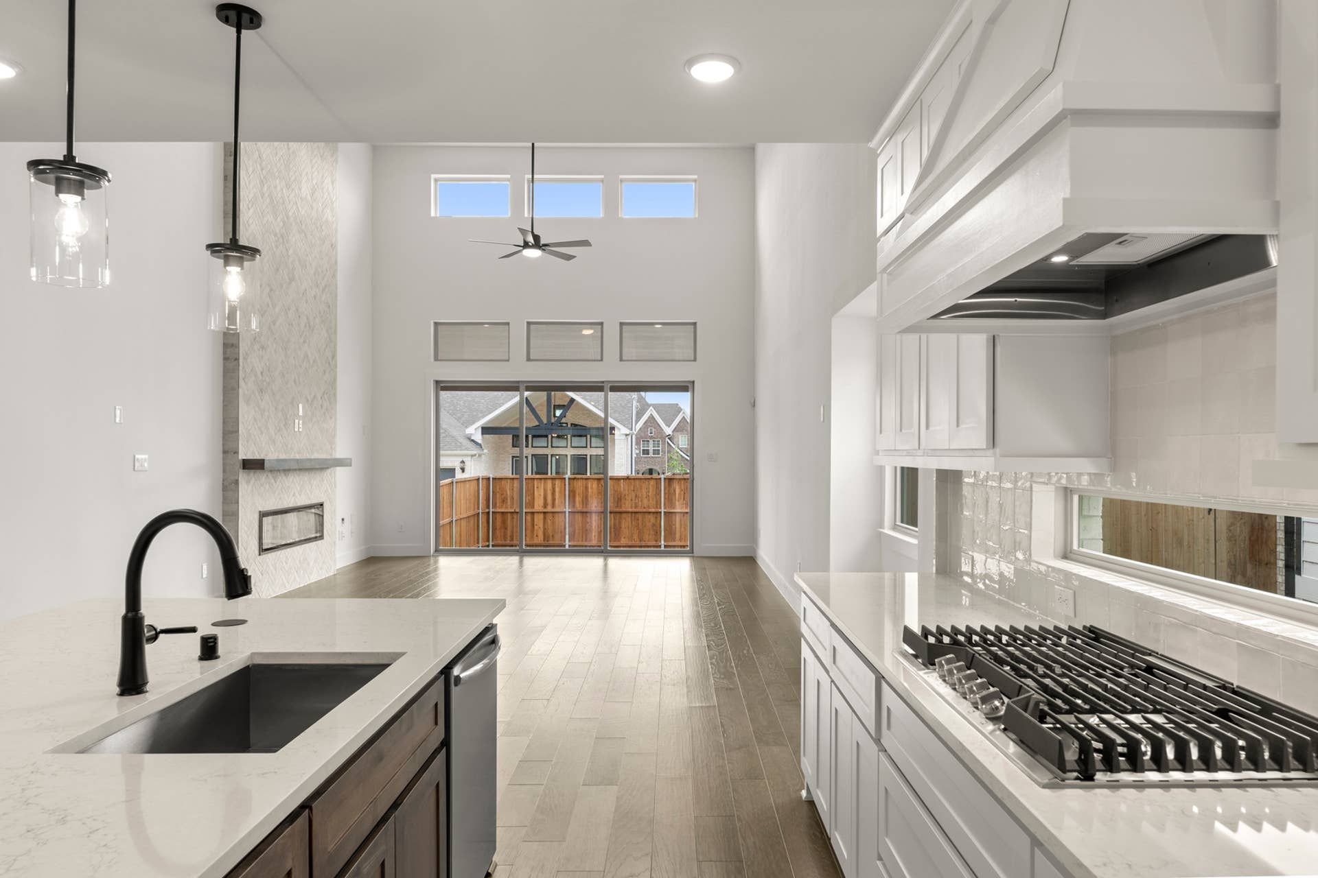 Modern kitchen with marble countertops, sleek cabinetry, and open layout to living area.