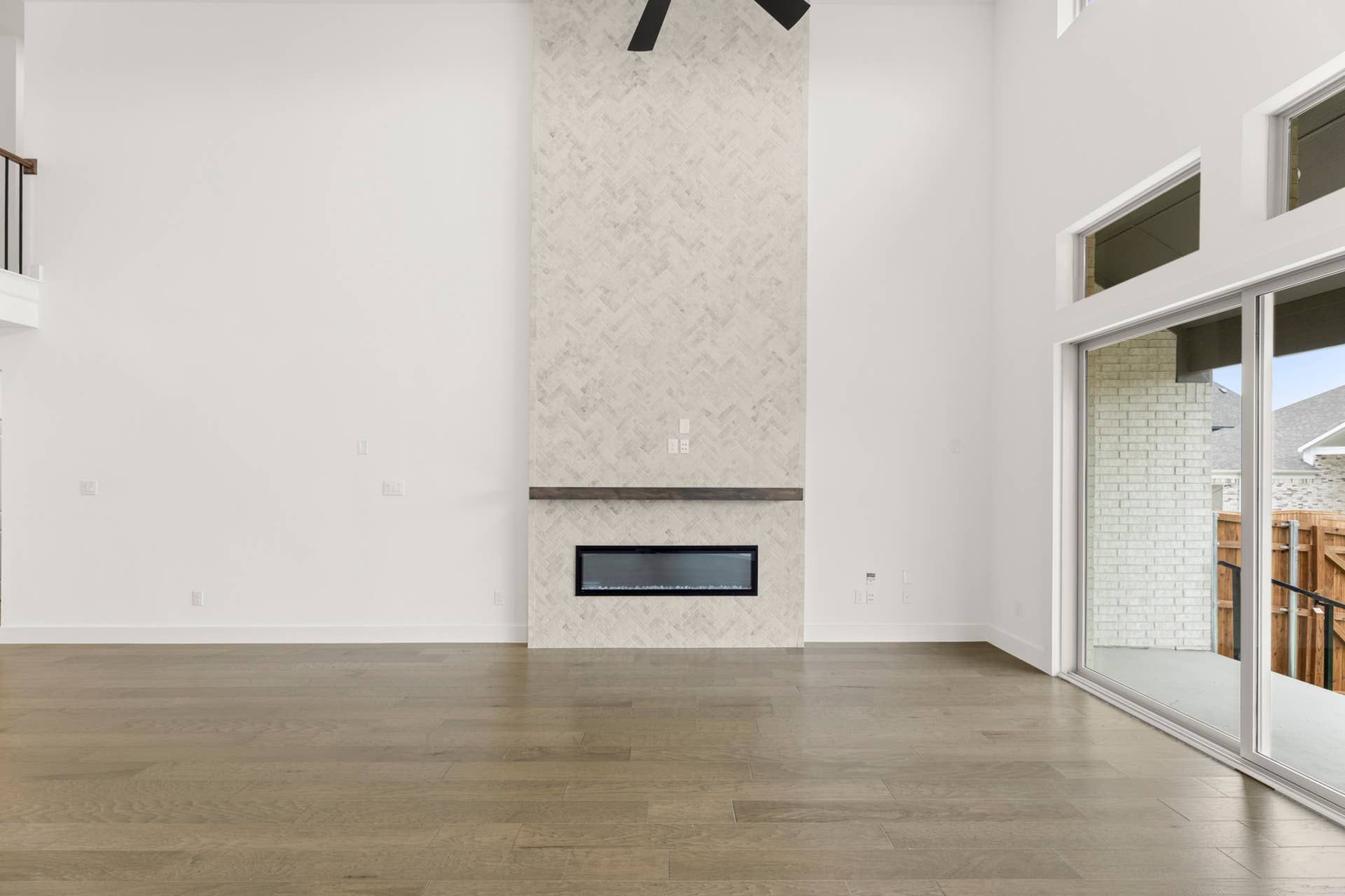 Spacious living room with modern fireplace and large windows.