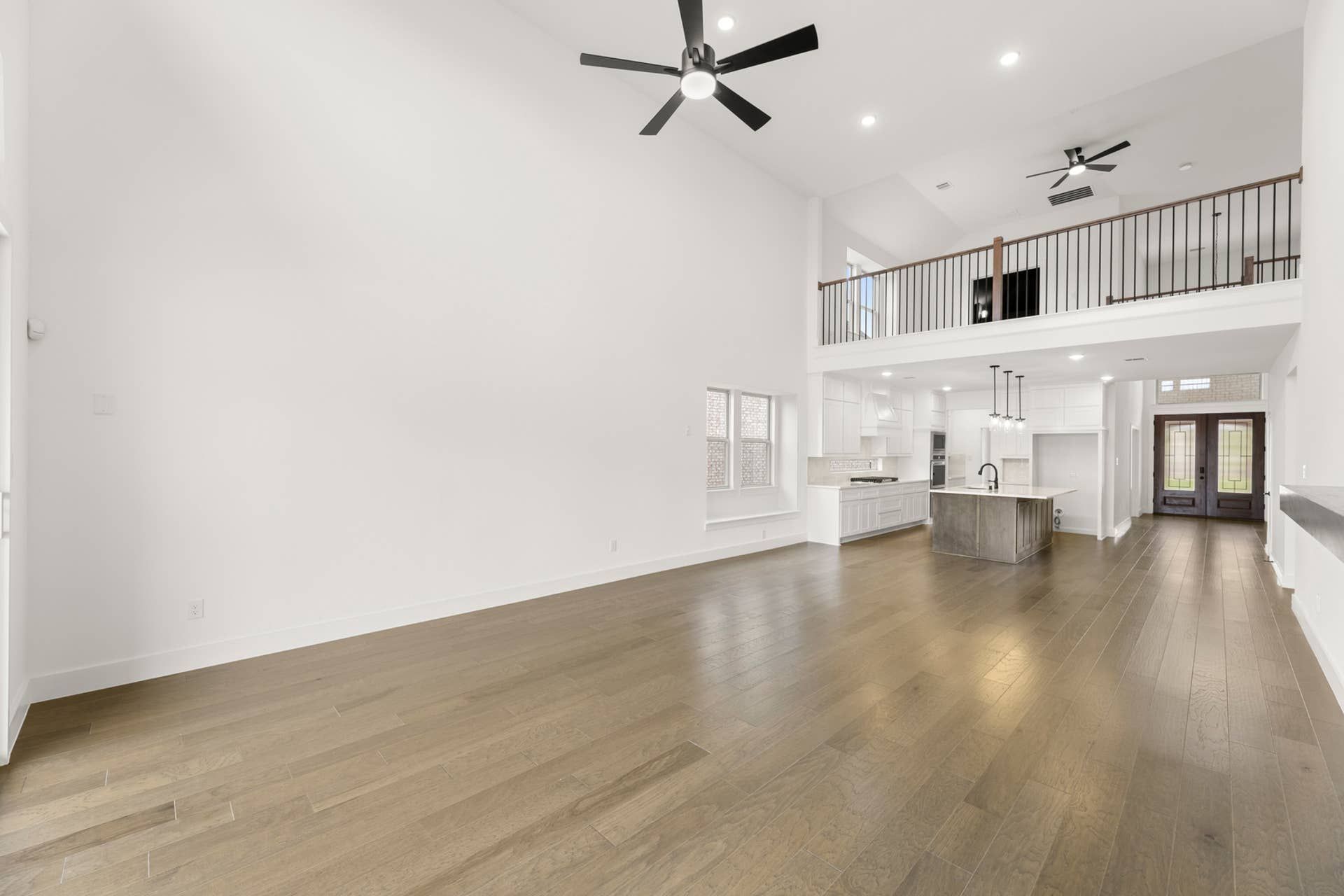 Spacious open-concept living area with high ceilings and modern kitchen.
