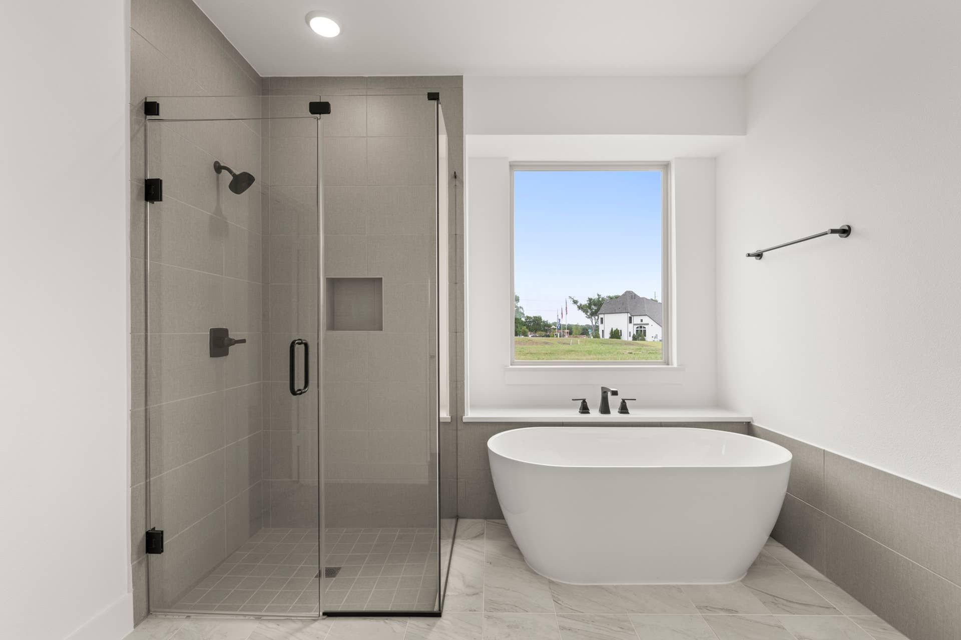 Modern bathroom with glass shower and freestanding bathtub.