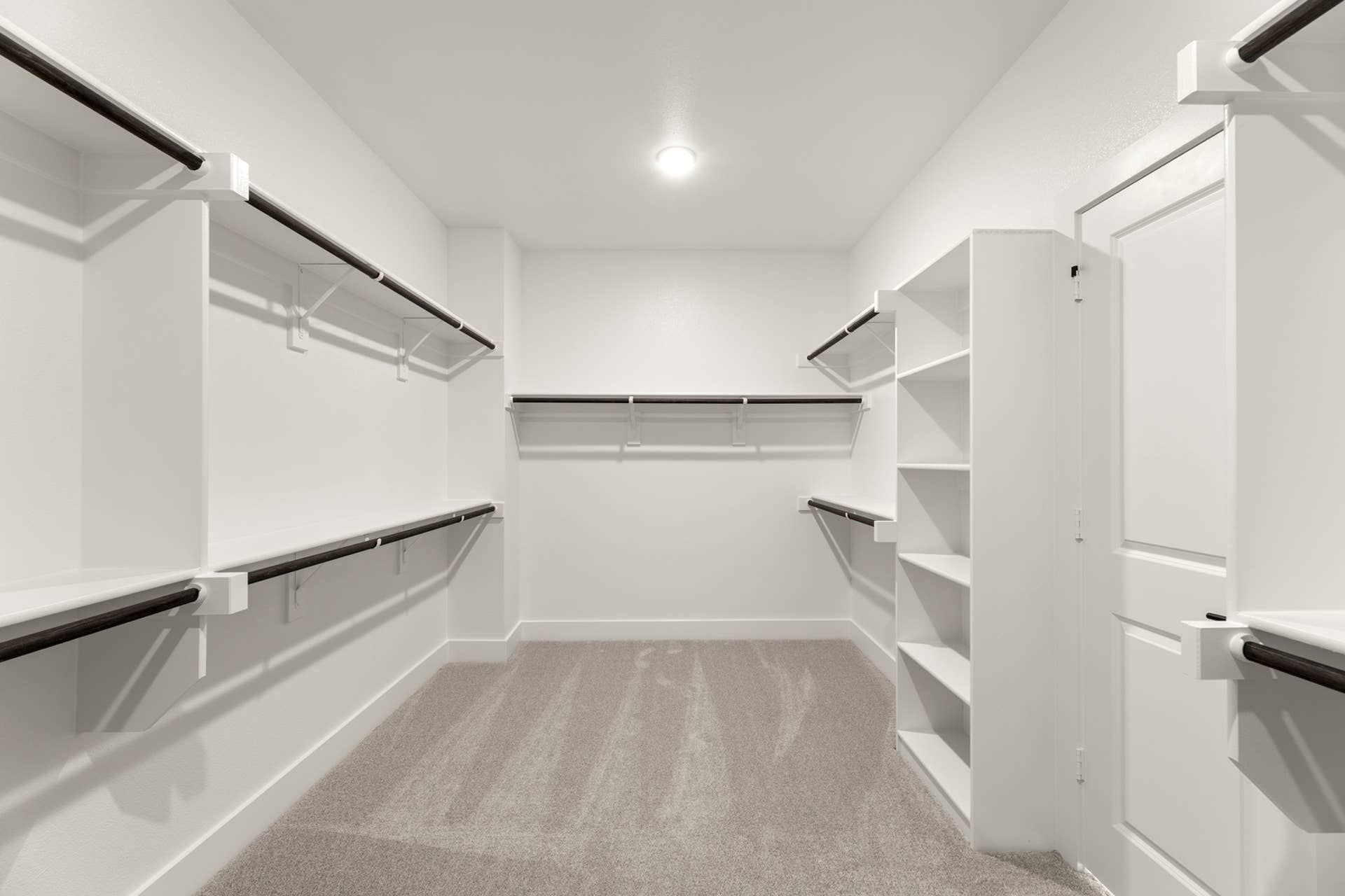 Spacious walk-in closet with built-in shelving and ample hanging space.