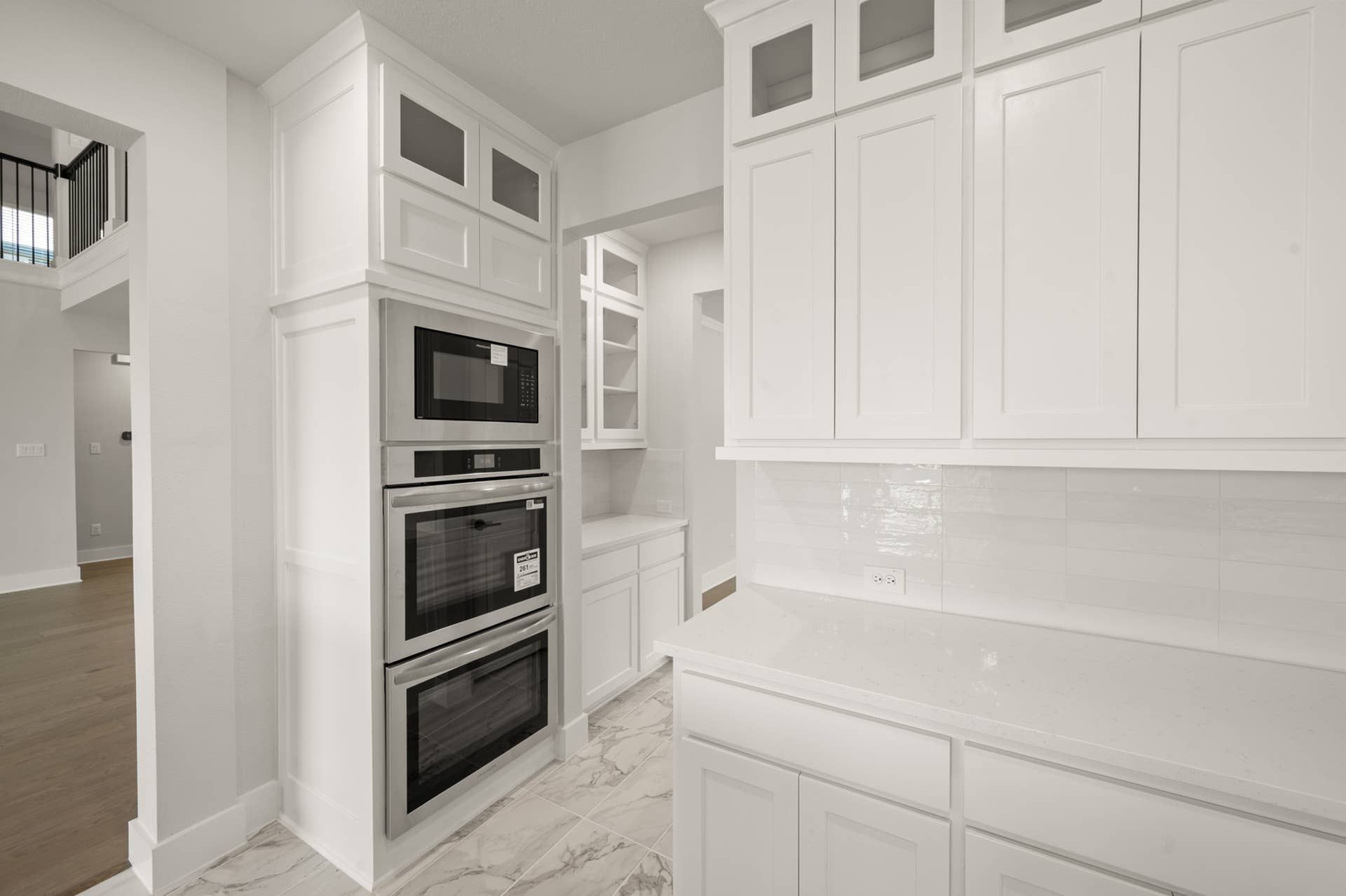 Modern kitchen interior with white cabinetry and built-in stainless steel appliances.