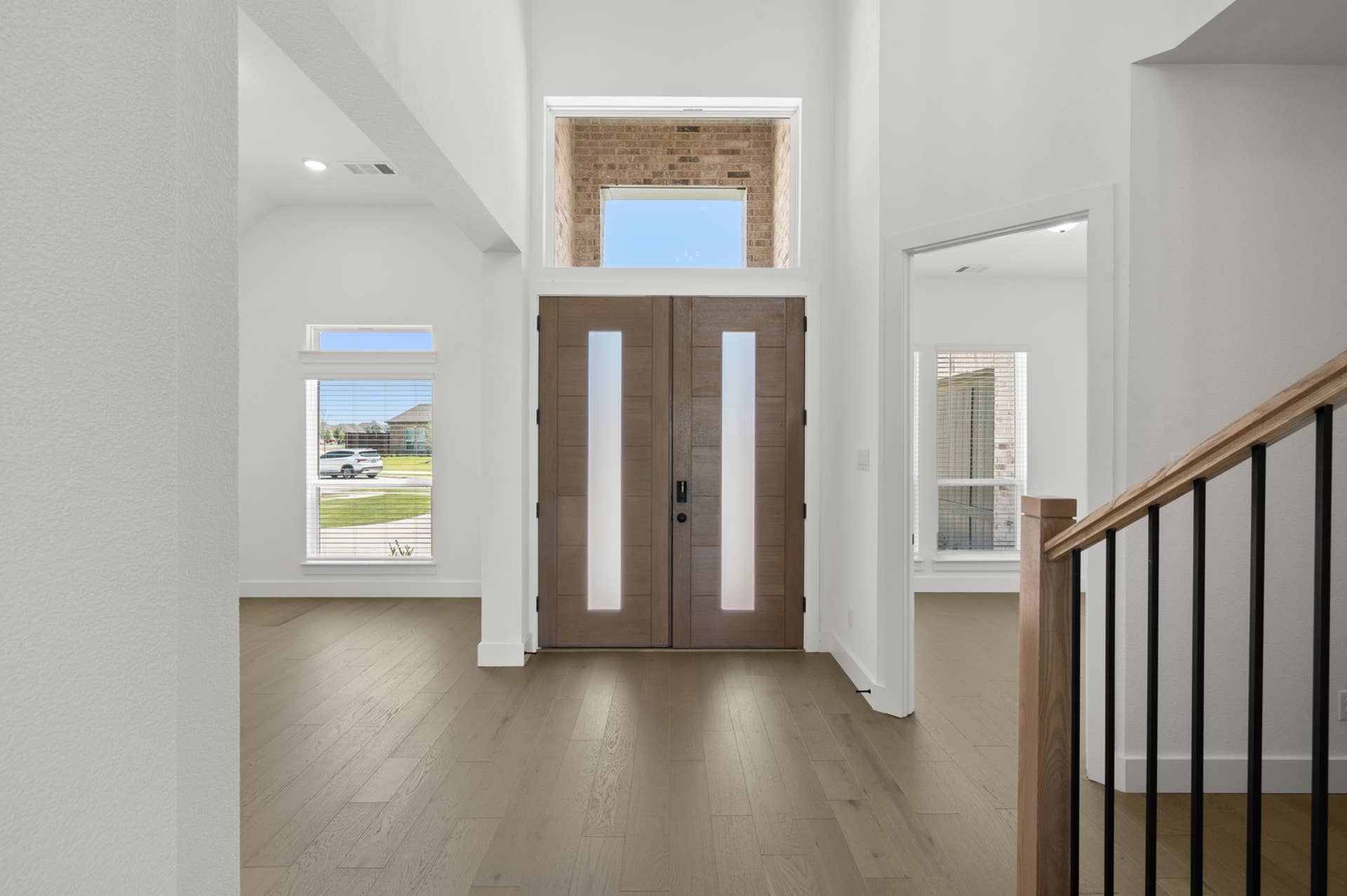 Modern entryway with double doors and hardwood flooring.