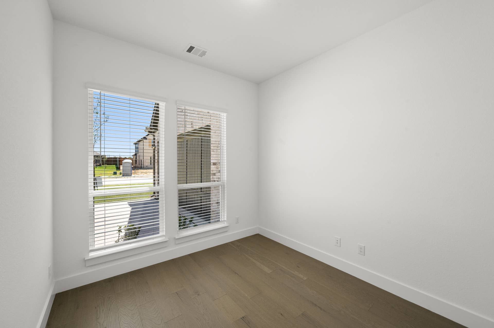 Bright study room with wood flooring and large windows.