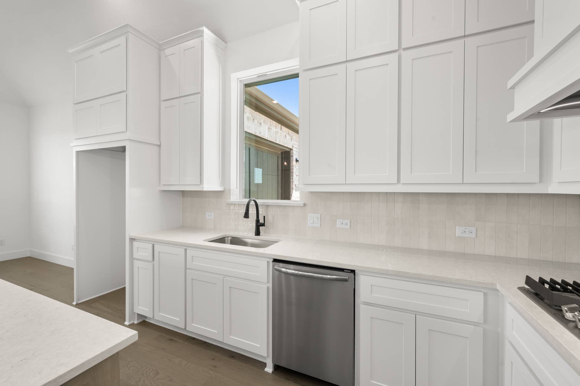 Modern kitchen with white cabinetry and stainless steel appliances.