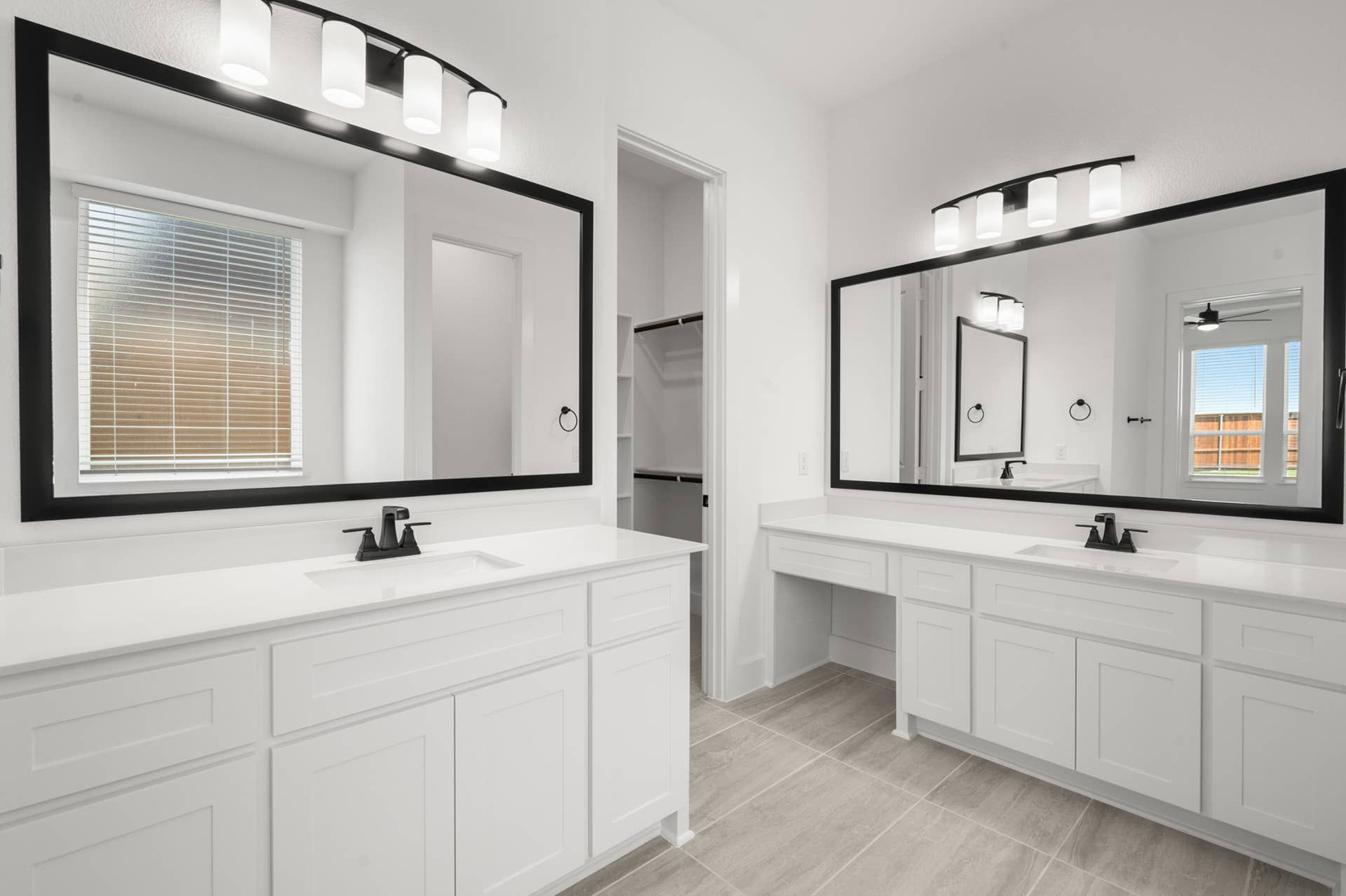 Spacious bathroom with dual vanities, large mirrors, and modern lighting.