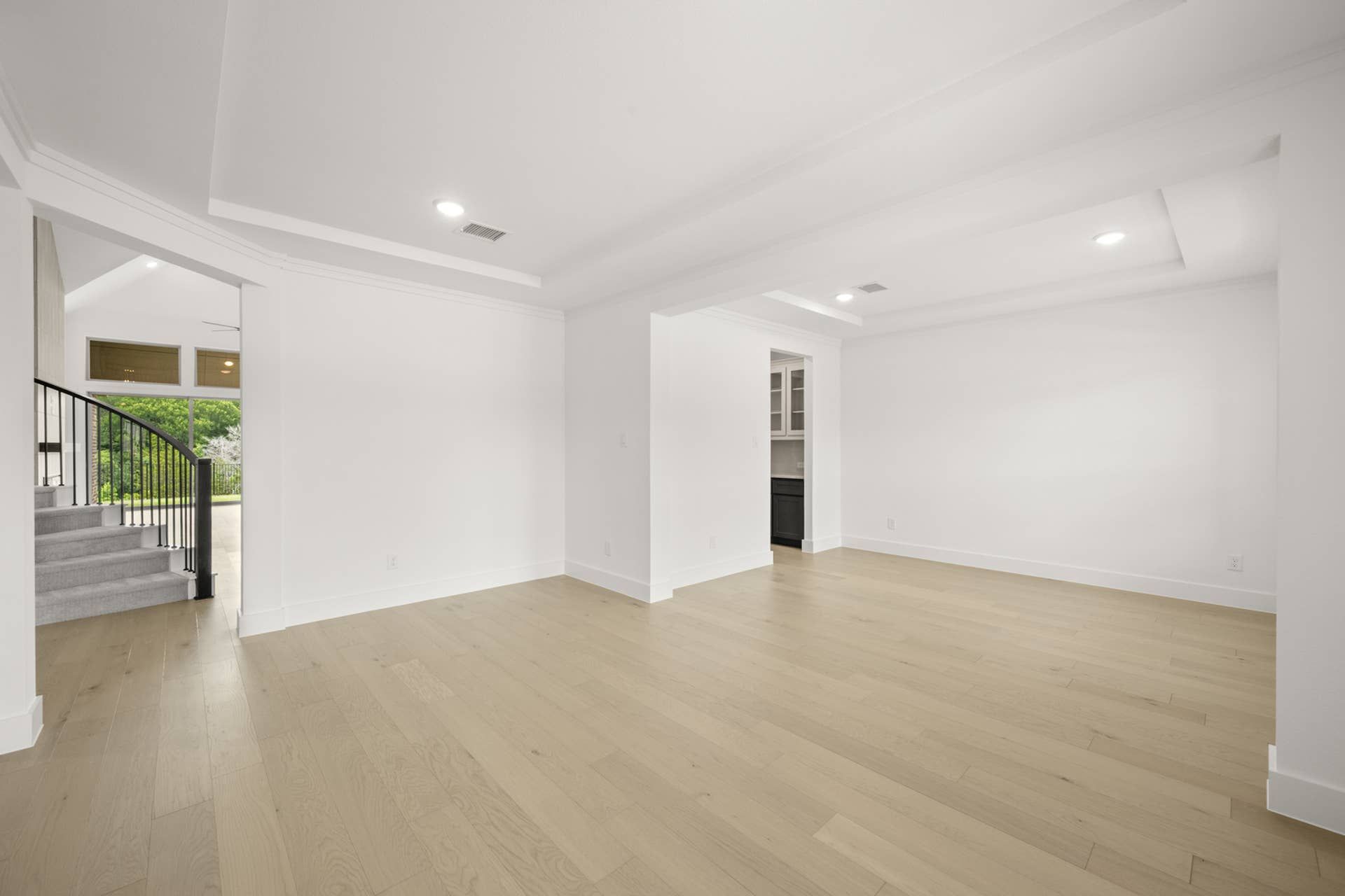 Spacious interior with light wood flooring and recessed lighting.