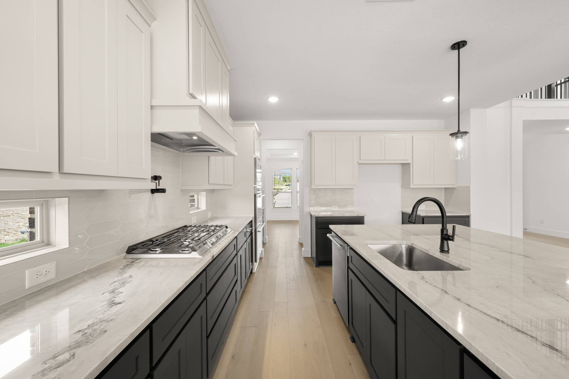 Modern kitchen with sleek cabinetry, marble countertops, and stainless steel appliances.