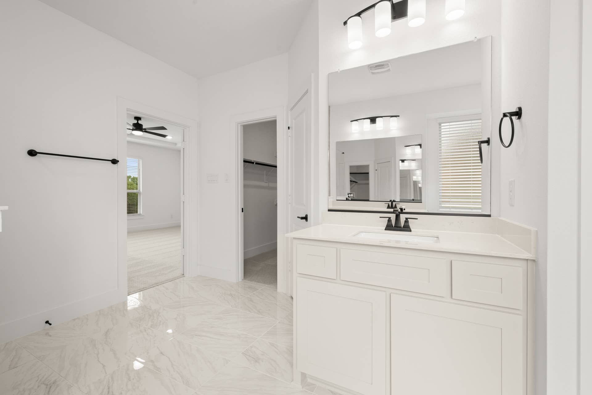 Spacious primary suite bathroom with modern fixtures and elegant marble flooring.