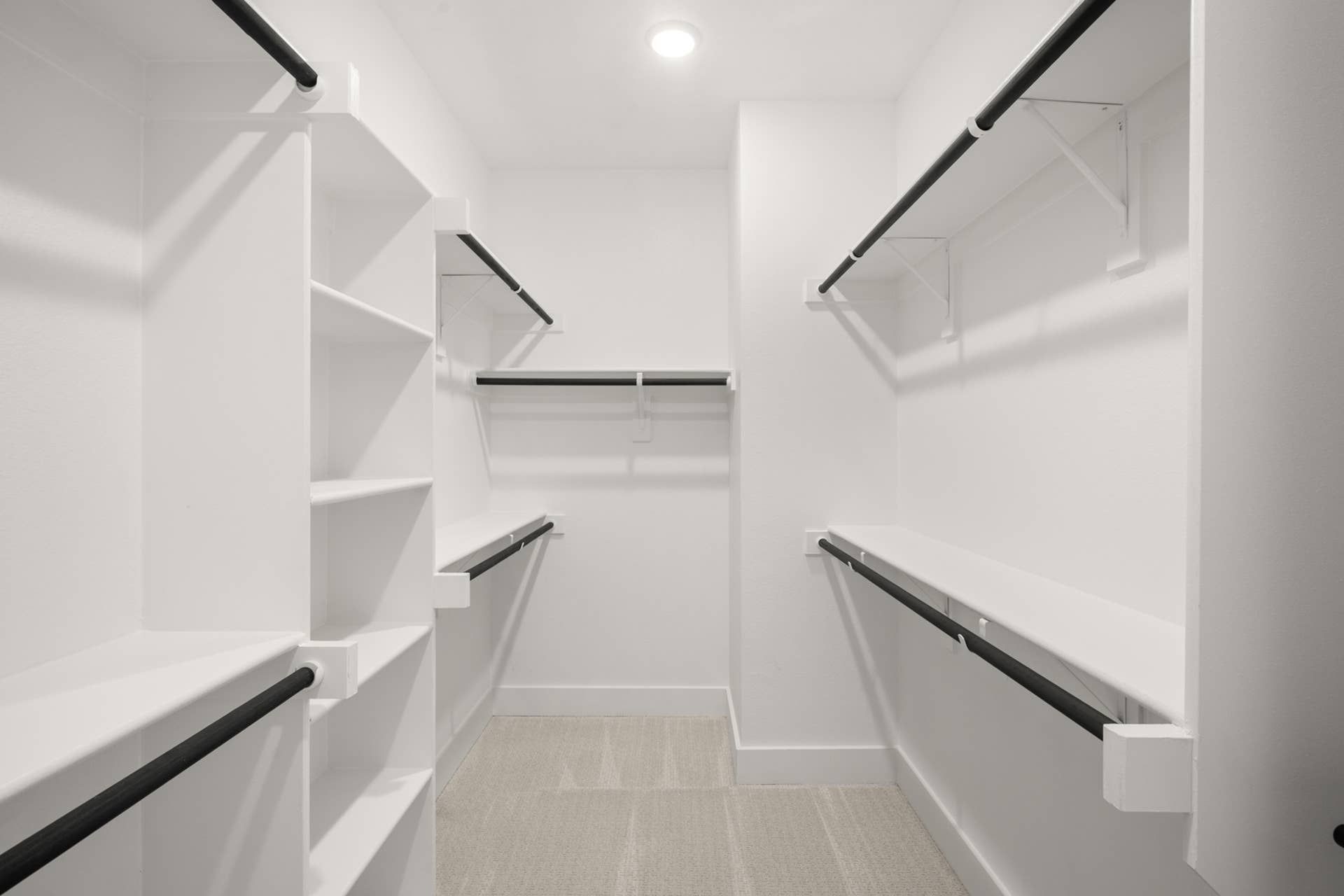 Spacious walk-in closet with built-in shelves and hanging rods.