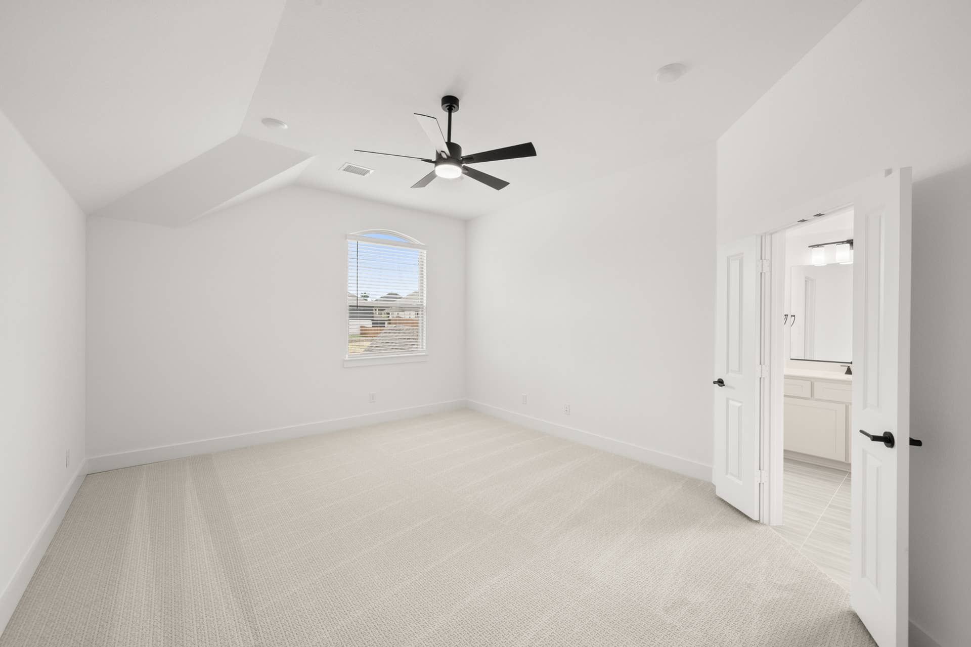 Spacious secondary suite with ceiling fan and adjoining bathroom in Hidden Lake home.