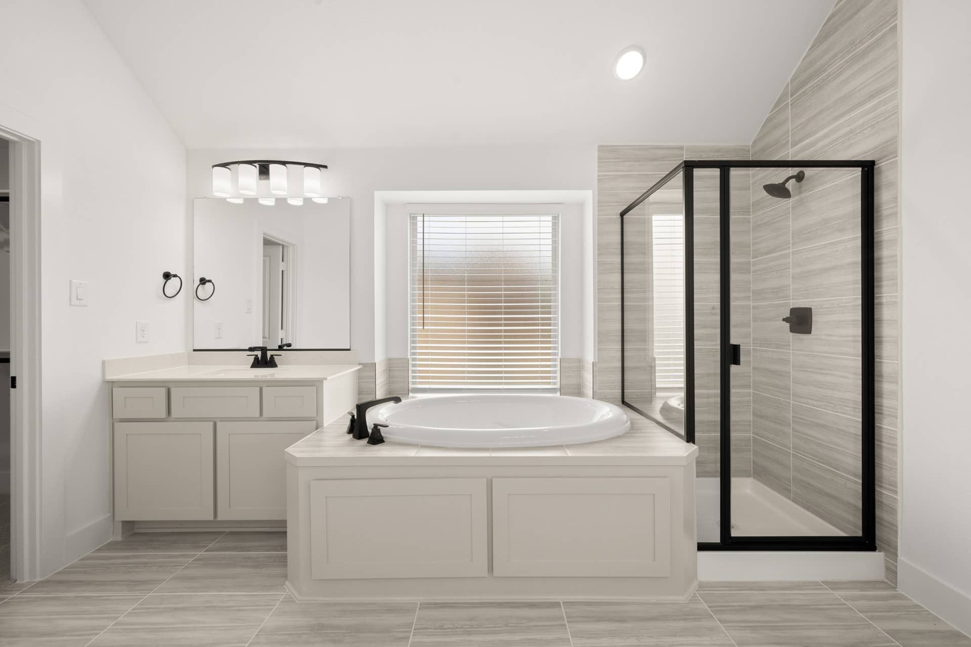 Modern bathroom with freestanding tub, glass shower, and elegant vanity.