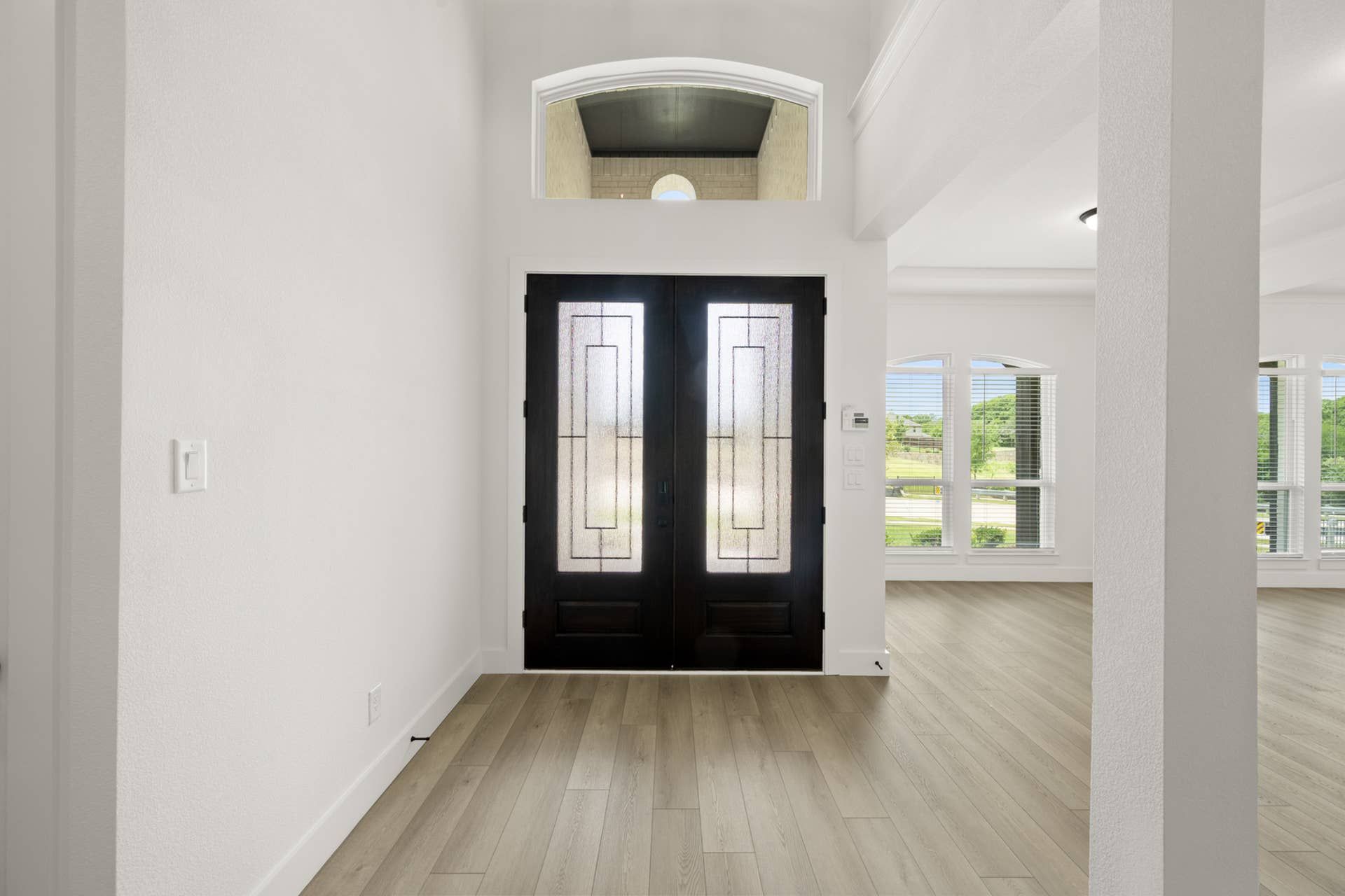 Spacious entryway with elegant double doors and natural light.