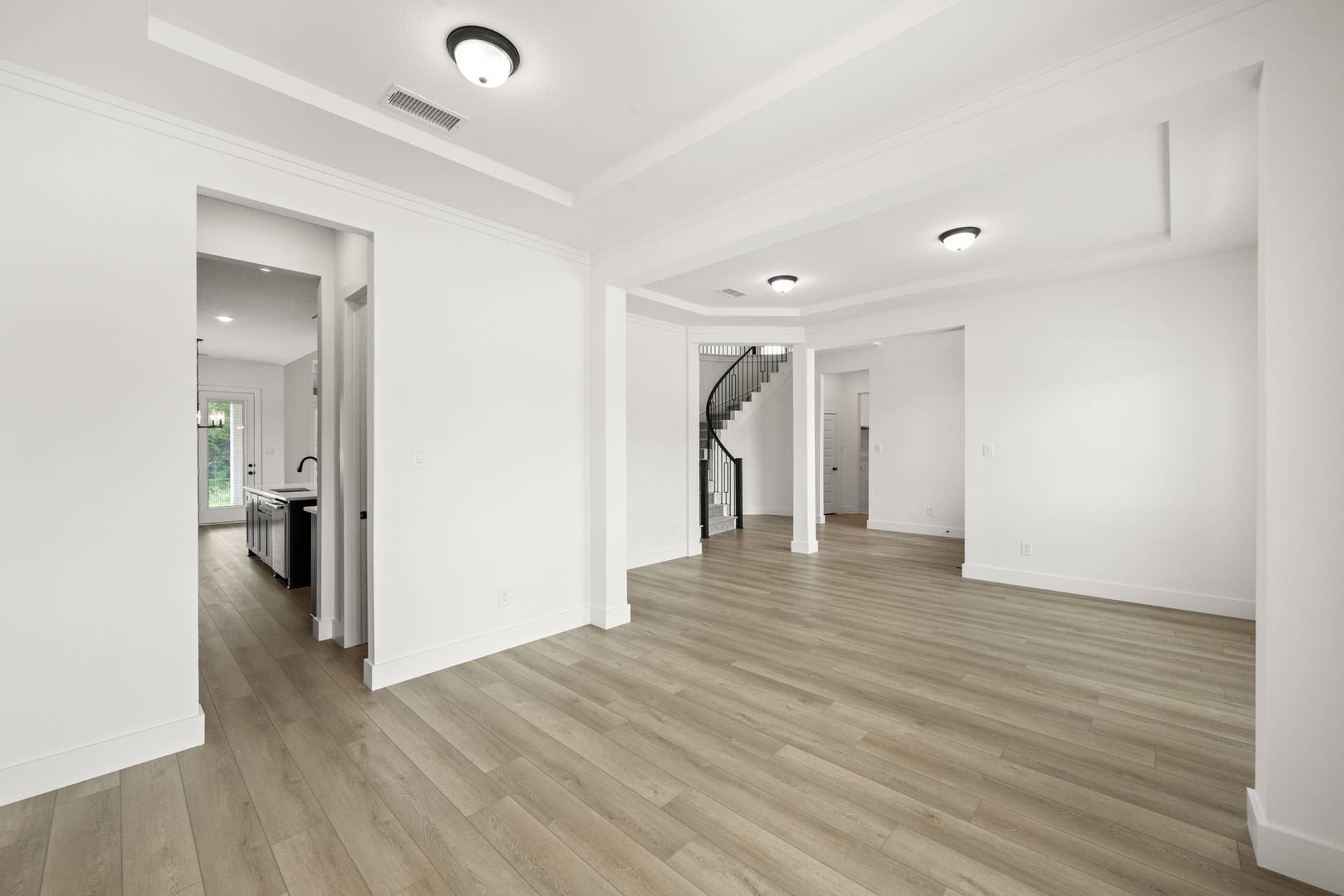 Spacious interior with hardwood floors and modern lighting fixtures.