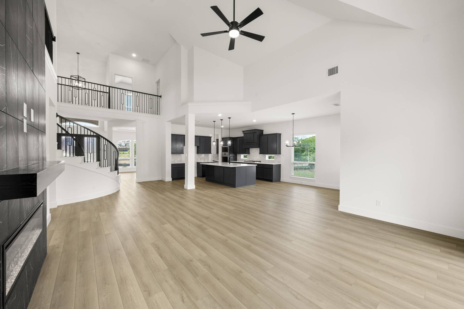 Spacious living room with elegant staircase and modern open kitchen design.