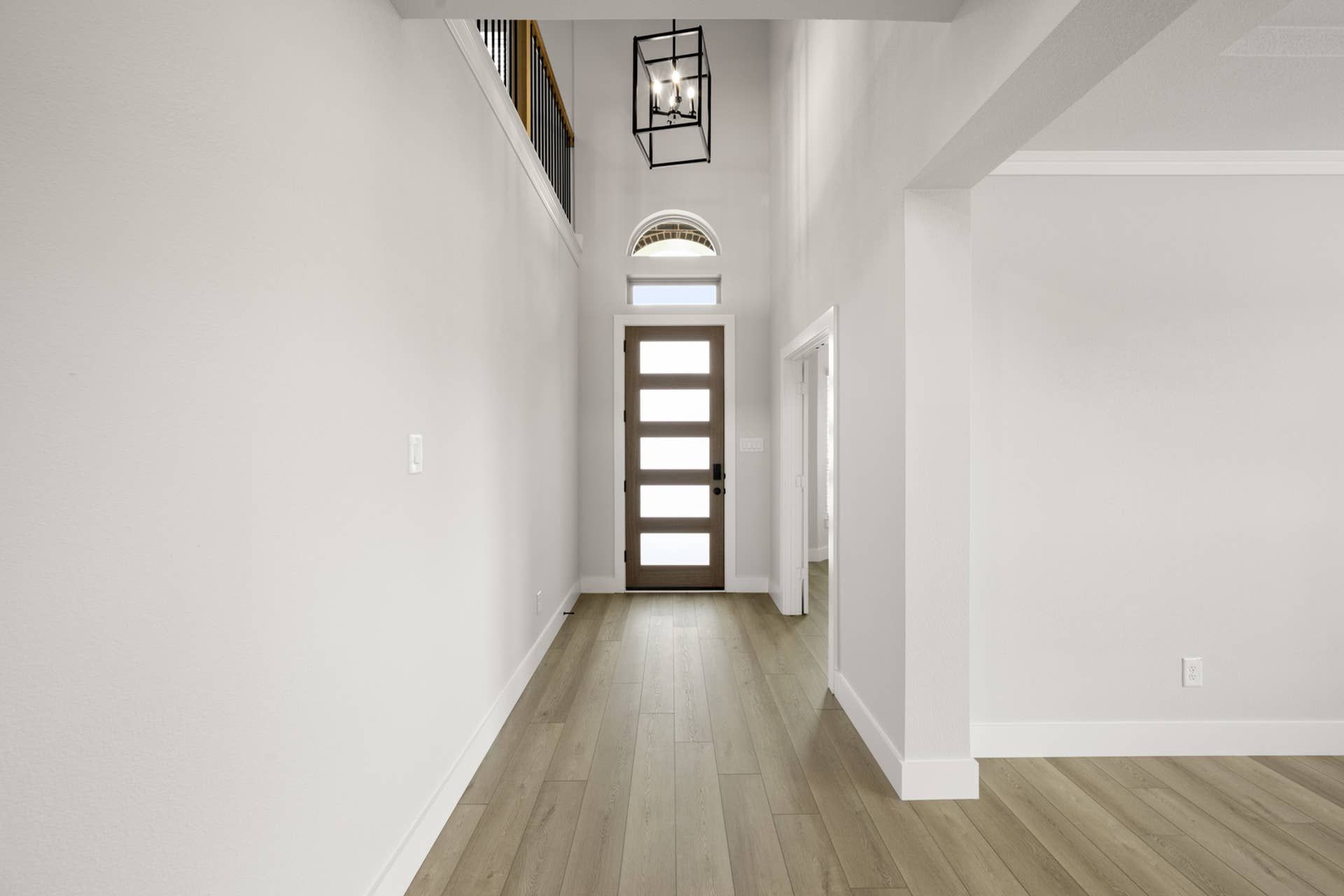 Modern entryway with wooden floor, geometric chandelier, and frosted glass door.