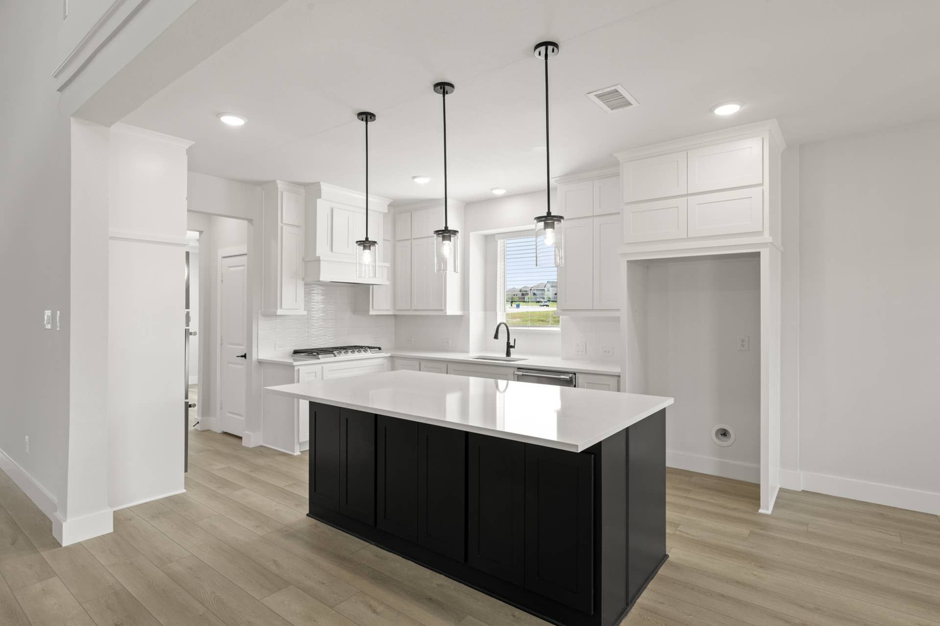 Modern kitchen with white cabinetry, island, and pendant lighting
