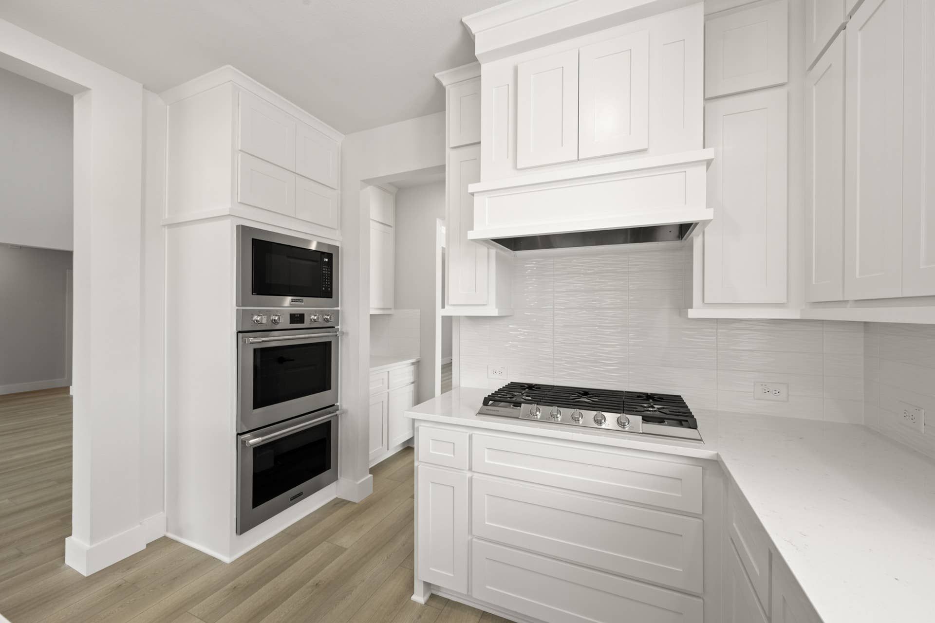 Modern kitchen with white cabinetry, stainless steel appliances, and gas cooktop.