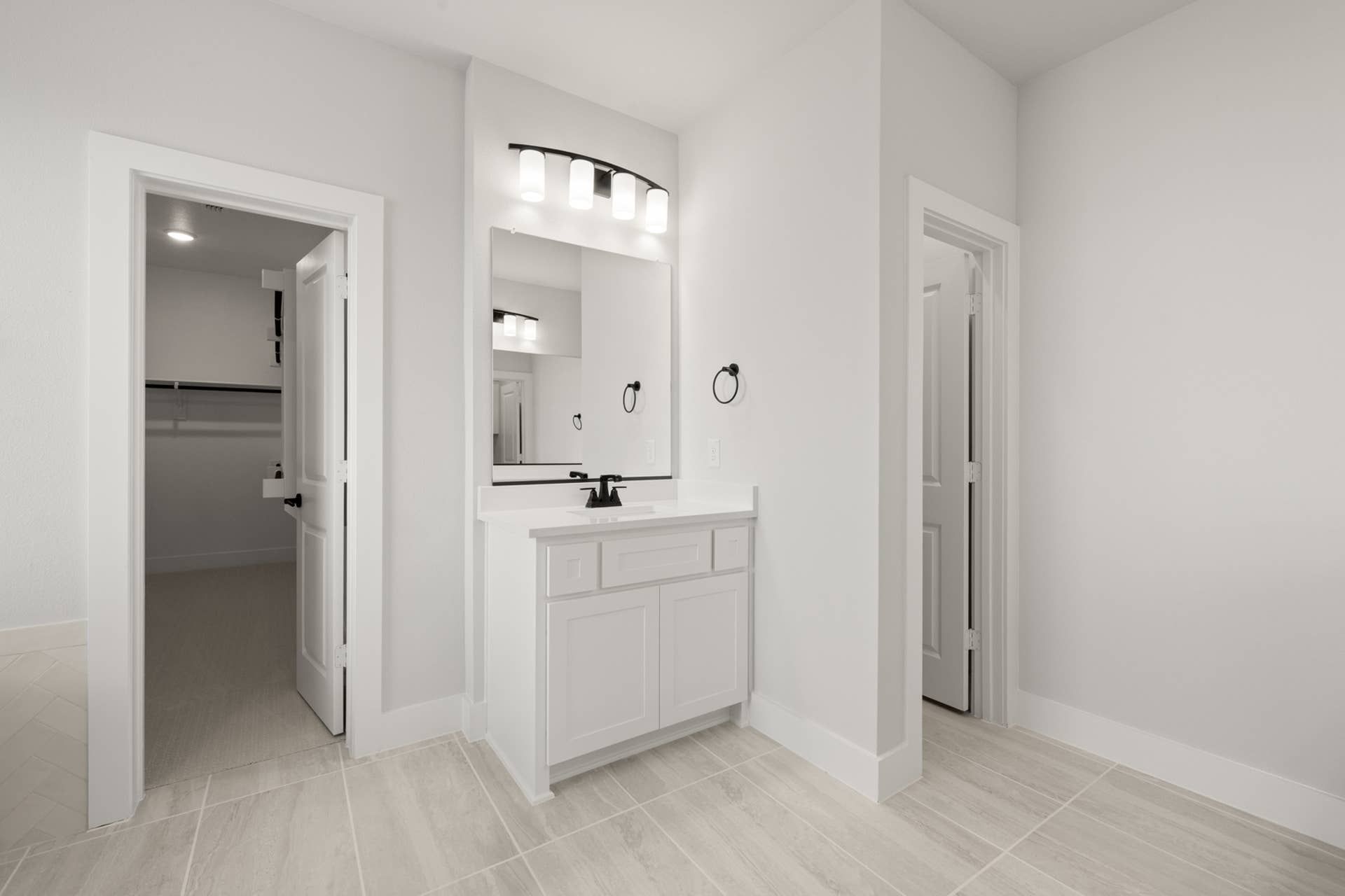 Spacious primary suite bathroom with modern vanity and walk-in closet.