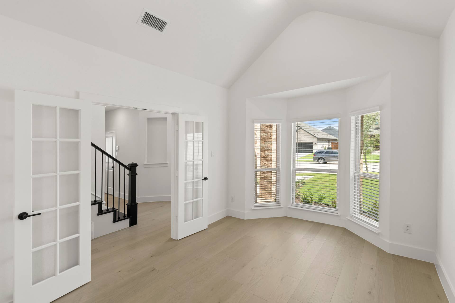 Bright dining room with French doors and large bay window.